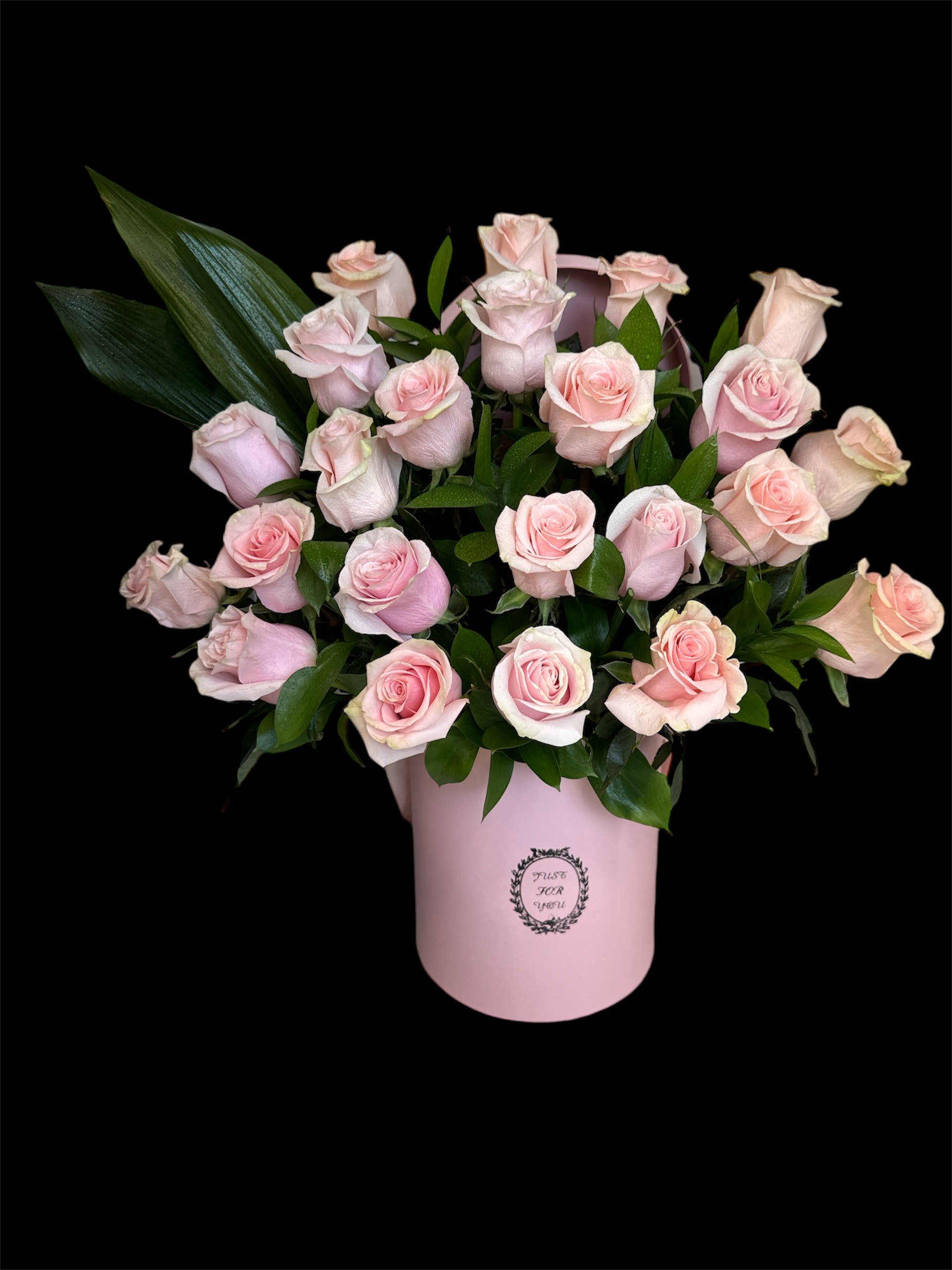 Pink roses arranged in a pale pink hatbox