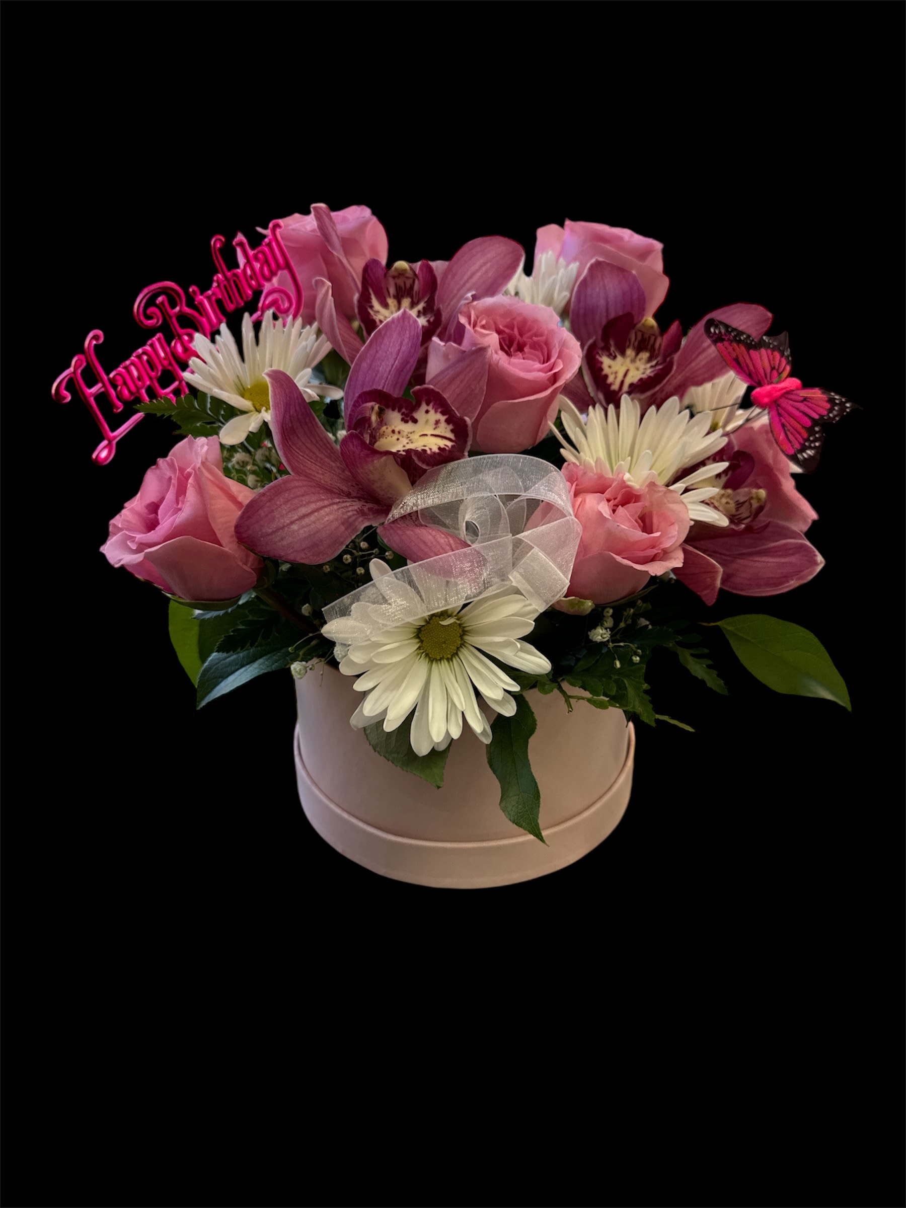 Pink and white flower arrangement in a round box with a birthday topper