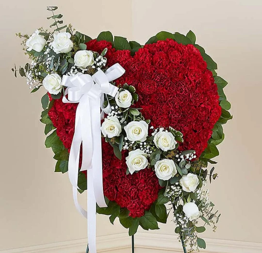 Heart-shaped red floral spray with white roses and a white ribbon