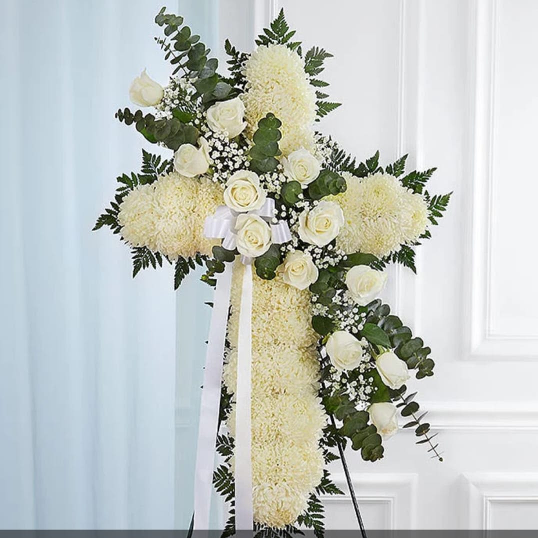 White floral cross arrangement with roses and ribbon