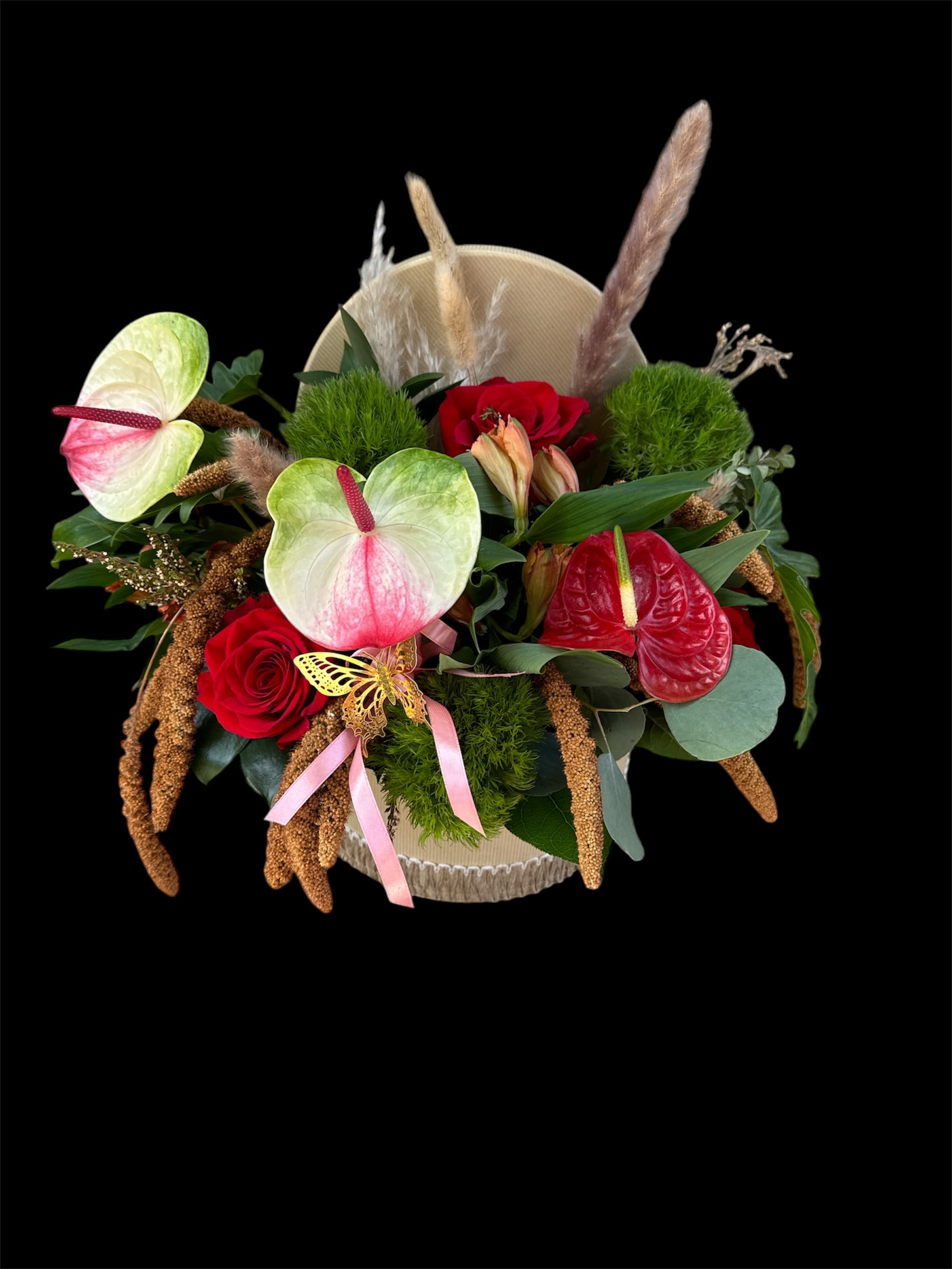 Mixed bouquet with red roses and pink anthuriums in a round box