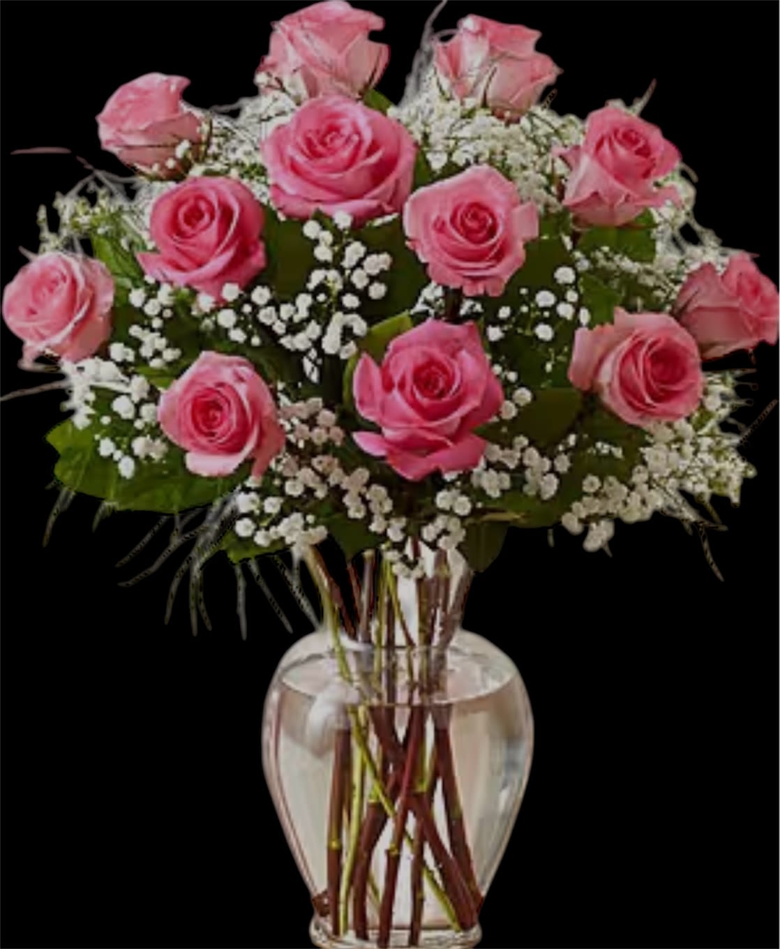Pink roses arranged in a clear glass vase with white baby's breath
