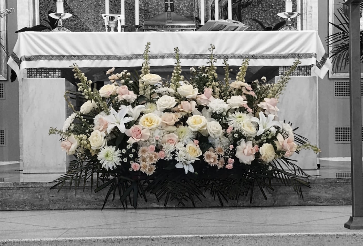 Large white and blush floral arrangement in front of an altar