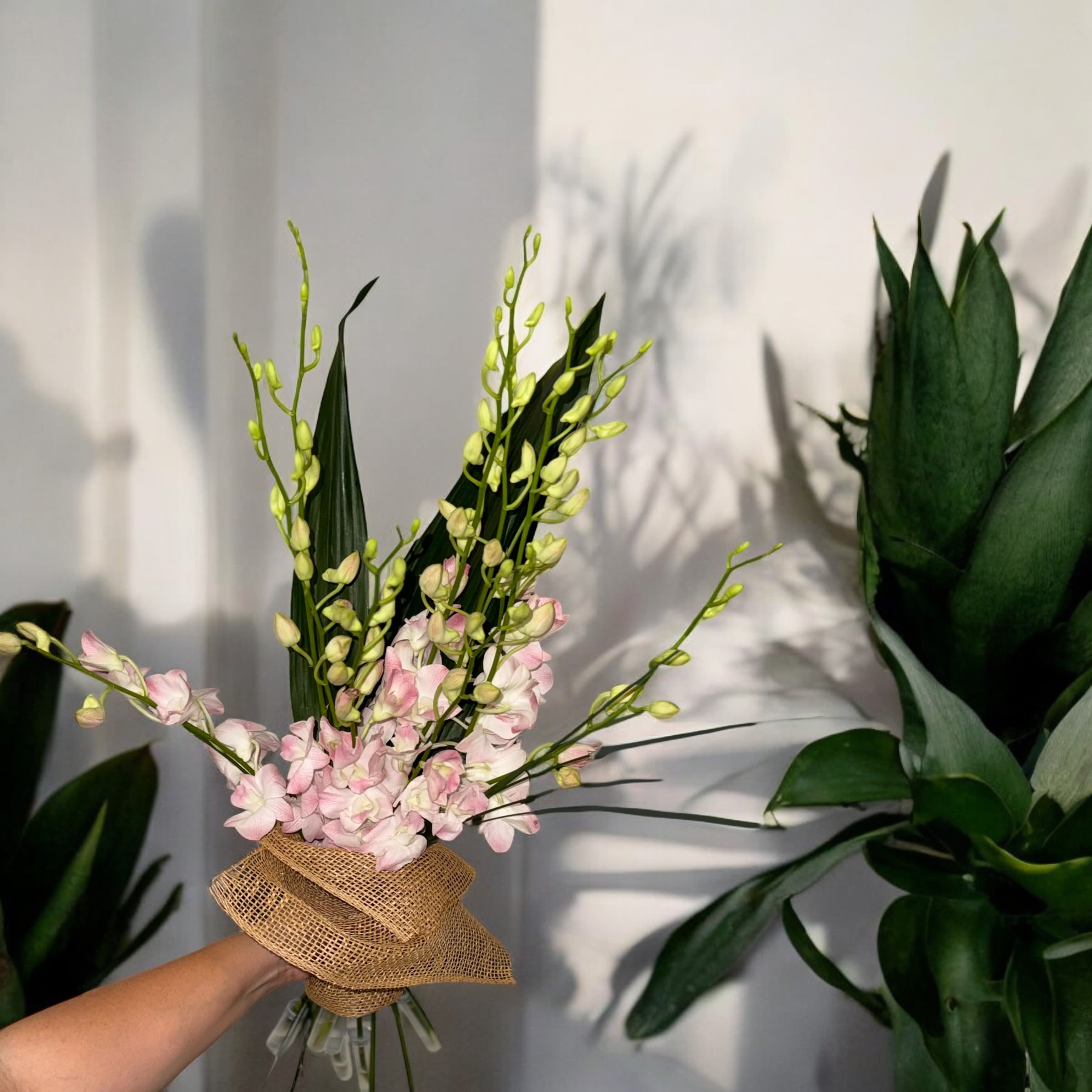 Pink orchid bouquet wrapped in burlap