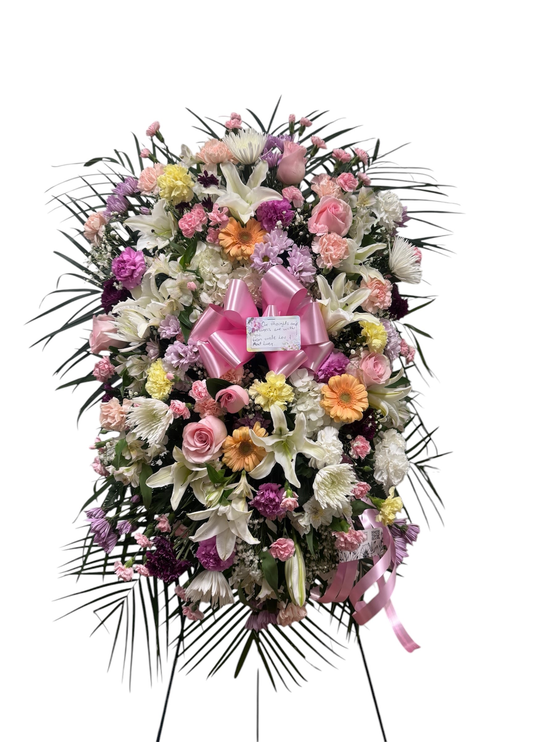Large standing floral spray with pink, white, and purple blooms and a pink ribbon