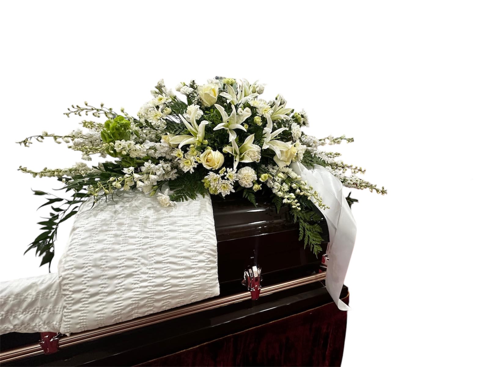 White floral spray on top of a dark casket
