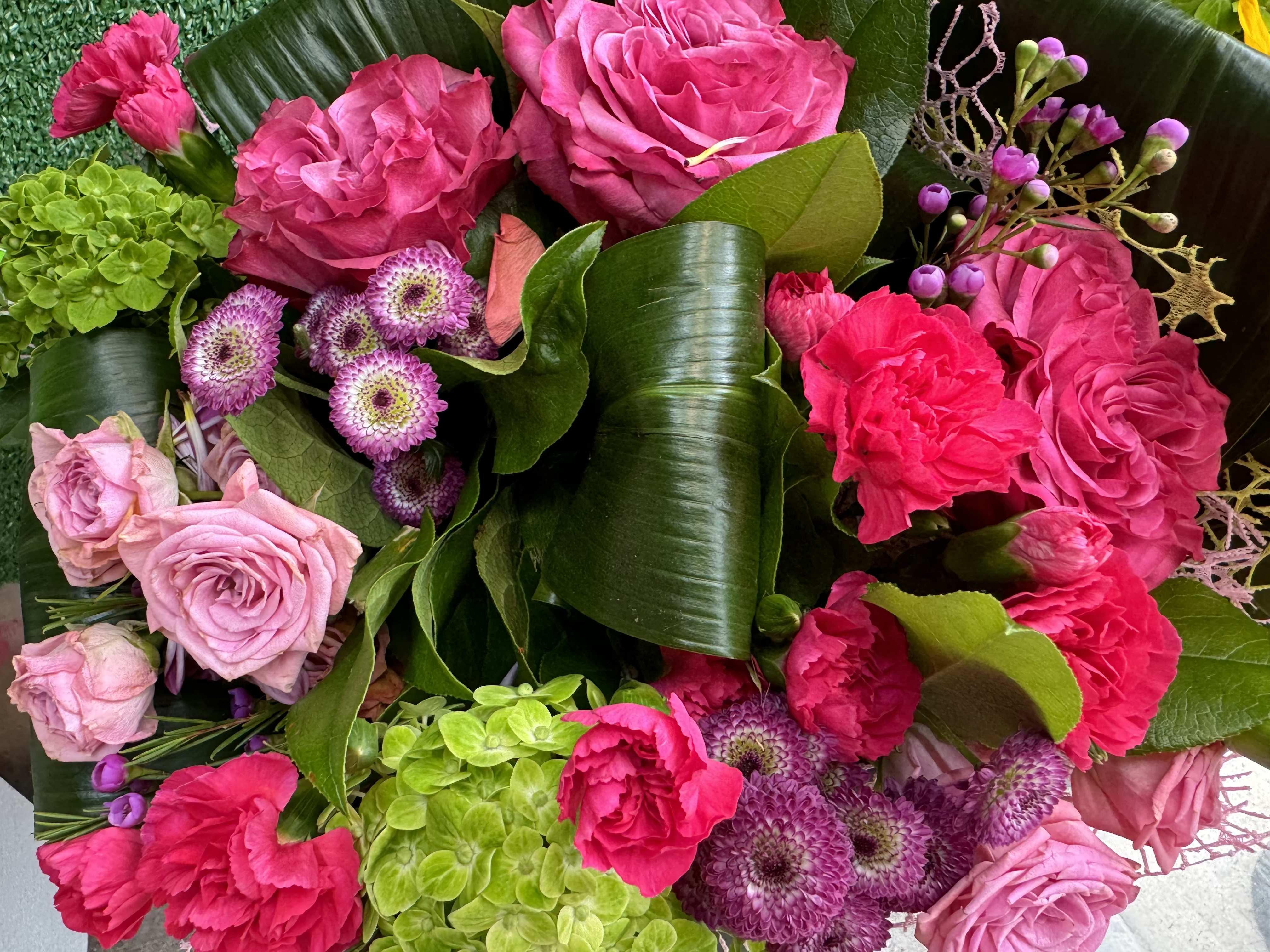 Pink and magenta rose bouquet with green hydrangeas and purple button flowers