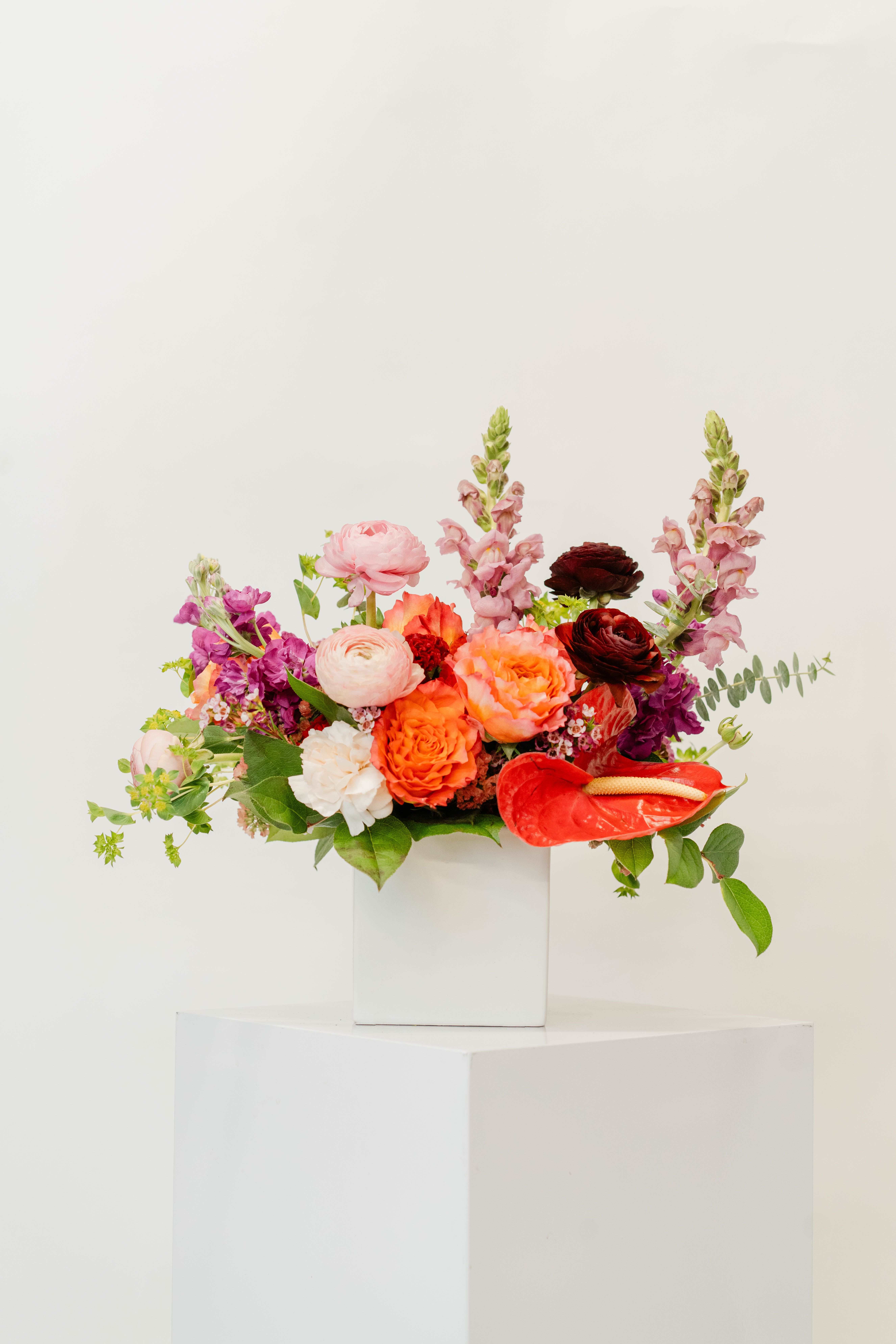 Colorful mixed bouquet in a white square vase