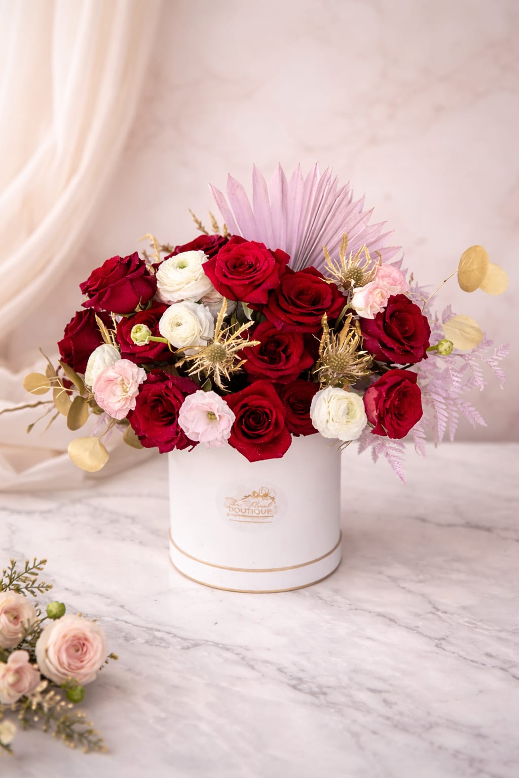 Red and white roses arranged in a white hat box
