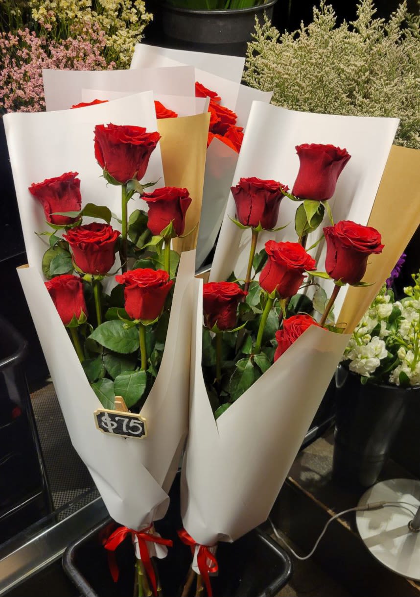 Two bouquets of red roses wrapped in white paper