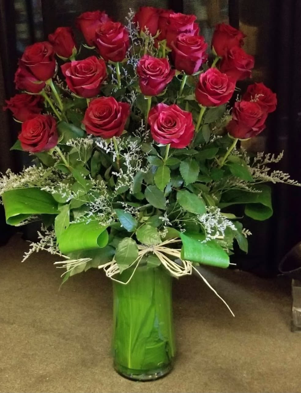 Bouquet of red roses in a tall green vase