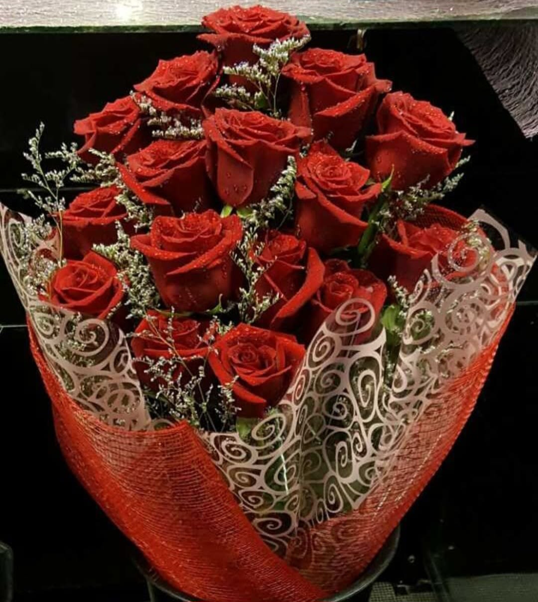 Bouquet of red roses wrapped in decorative red and white paper