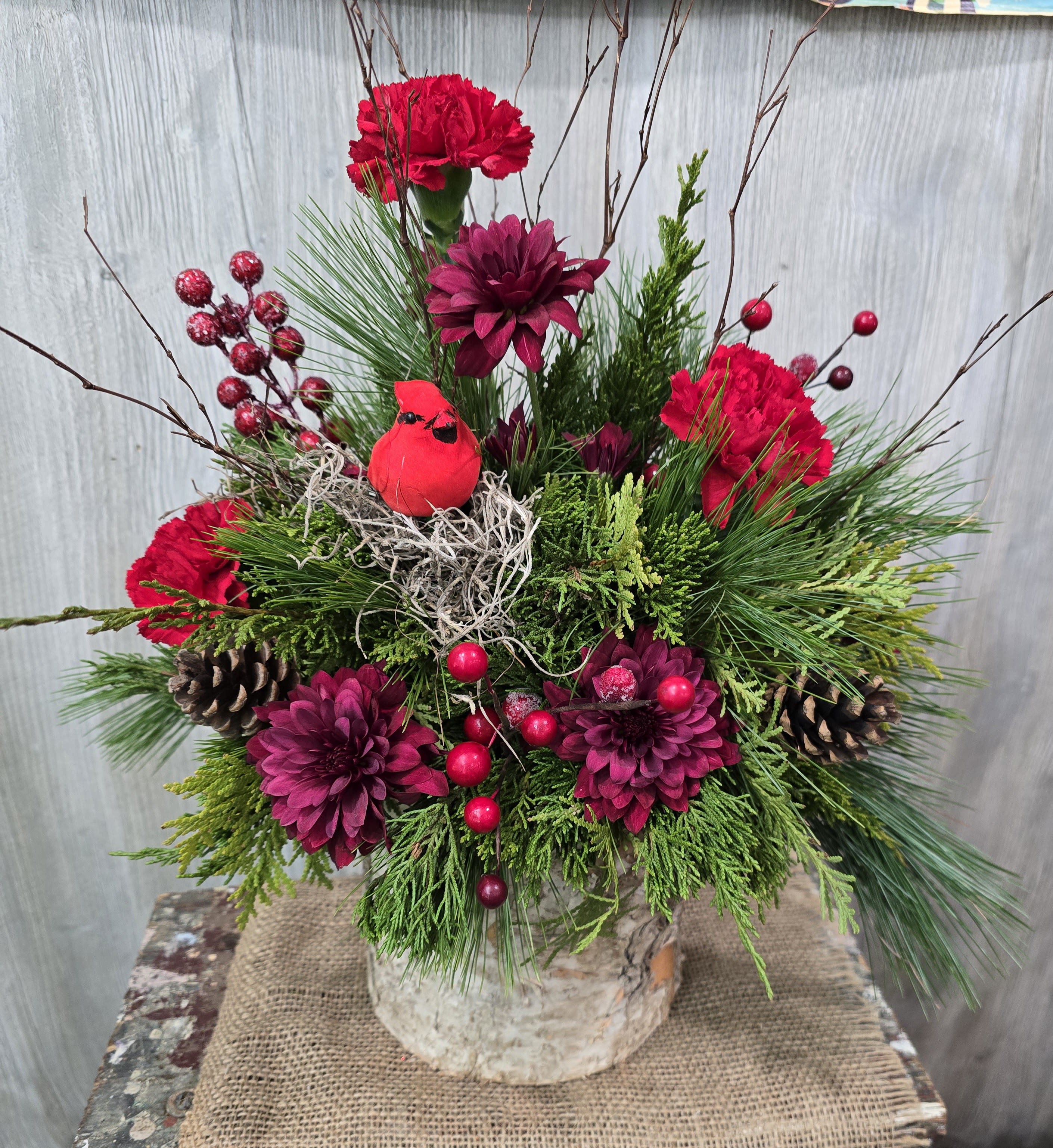 Christmas Cardinal  - A beautiful birch wood container full of fresh pine, flowers, and cardinal. Deluxe and premium pricing options include more flowers. 