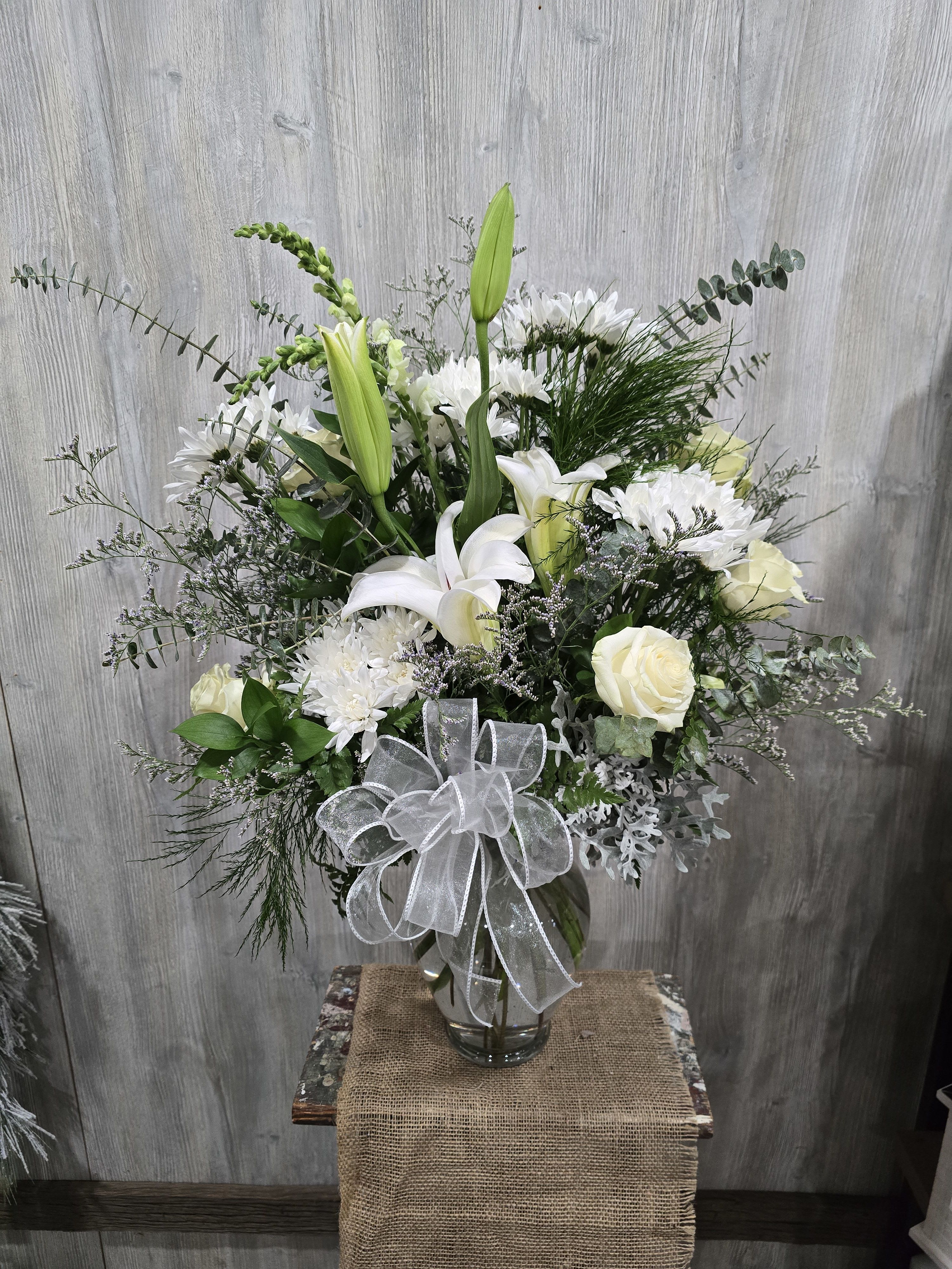 Ivory  - A beautiful vase arrangement full of white ivory blooms and lilies. Additional flowers and fullness are added with deluxe and premium pricing. 