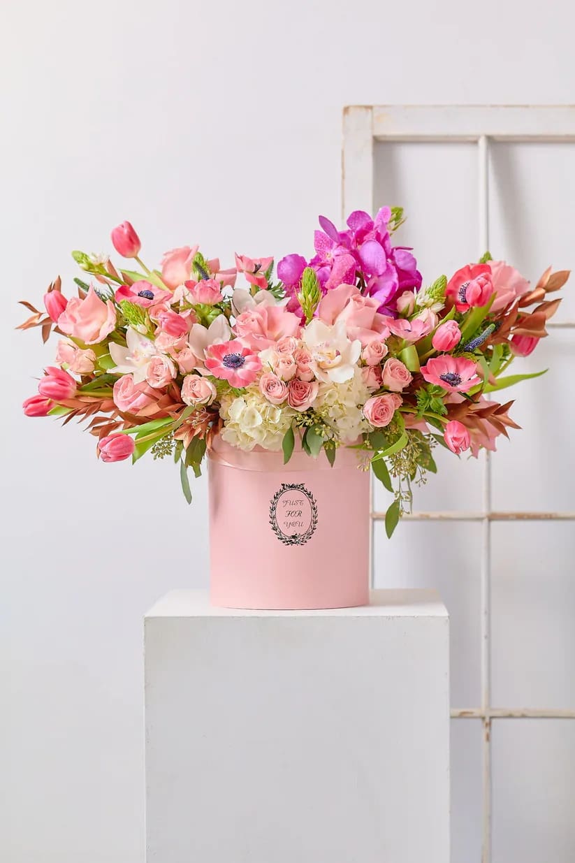 Pink and white mixed flower arrangement in a pink hat box