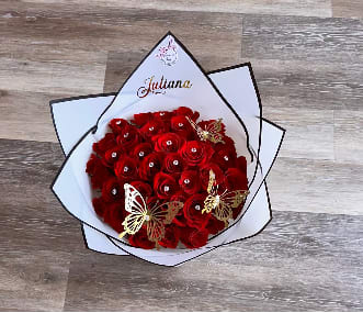 Bouquet of red roses wrapped in white paper with butterfly accents