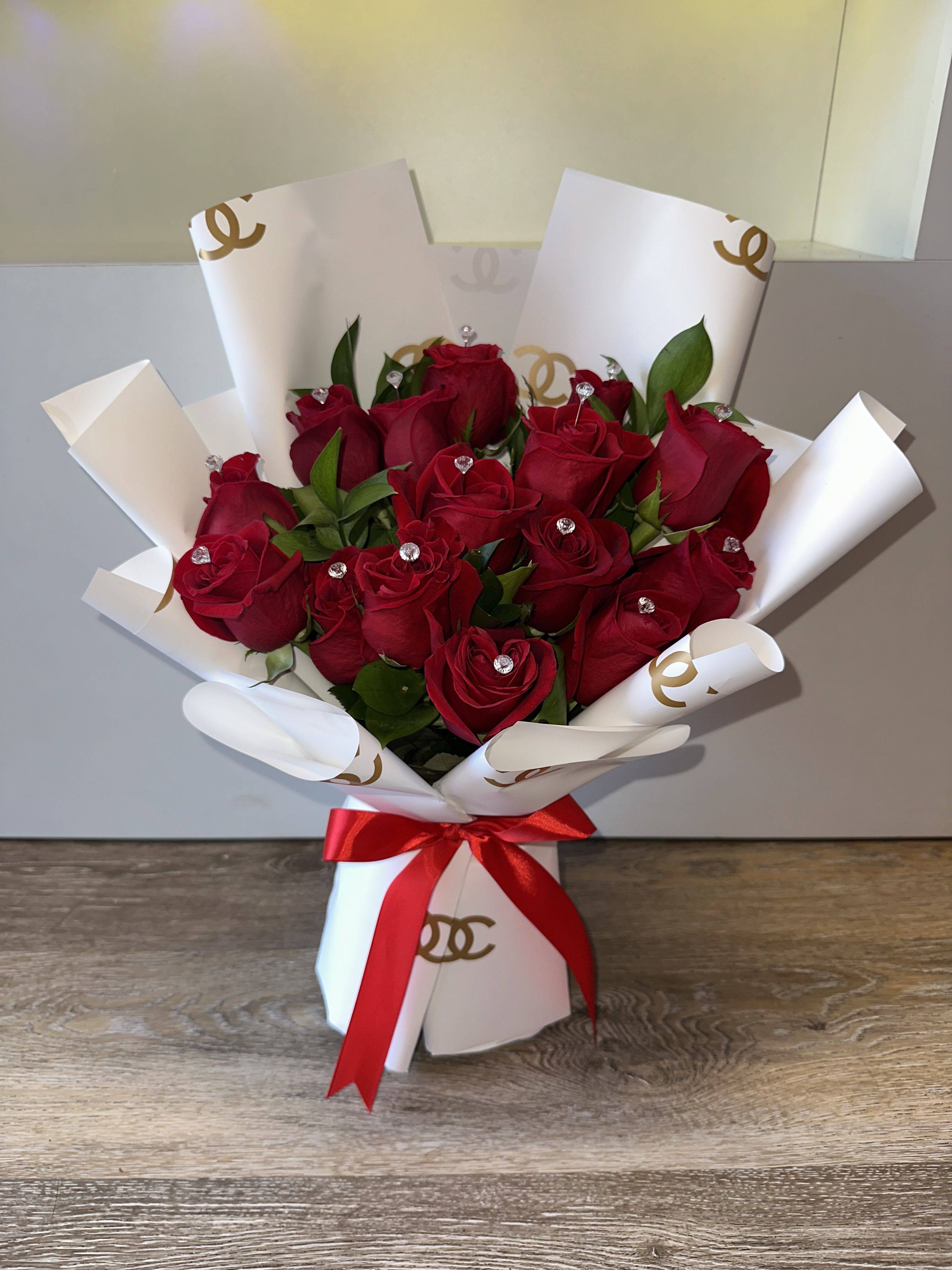 Bouquet of red roses wrapped in white paper with a red ribbon