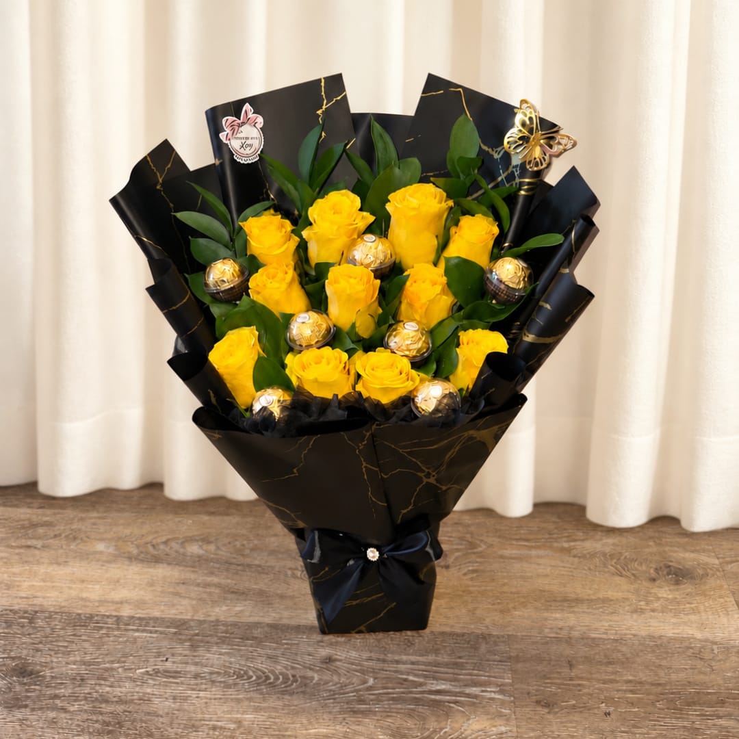 Bouquet of yellow roses with gold-wrapped chocolates in black paper