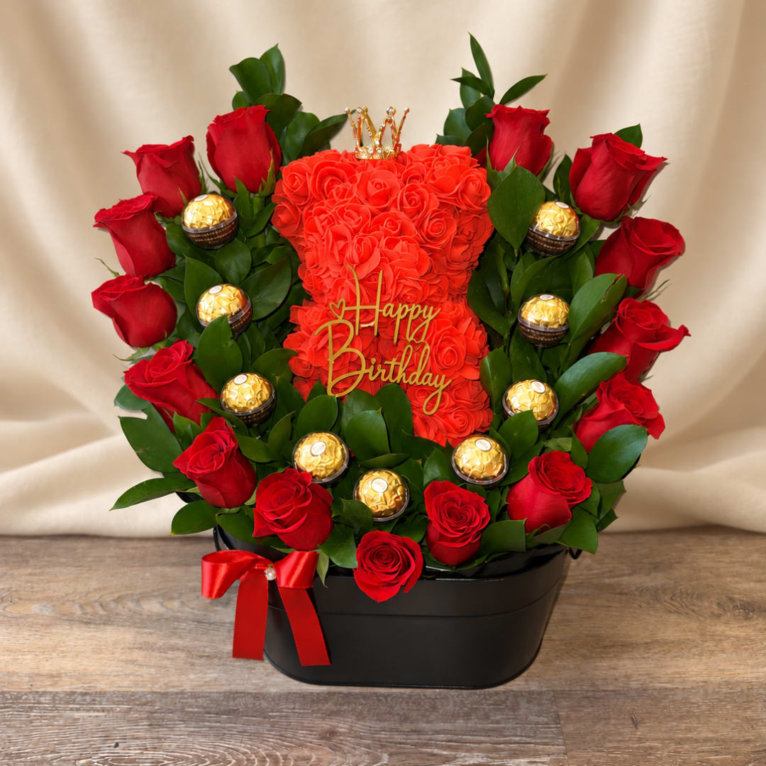 Red rose arrangement with chocolates and a Happy Birthday topper in a black box