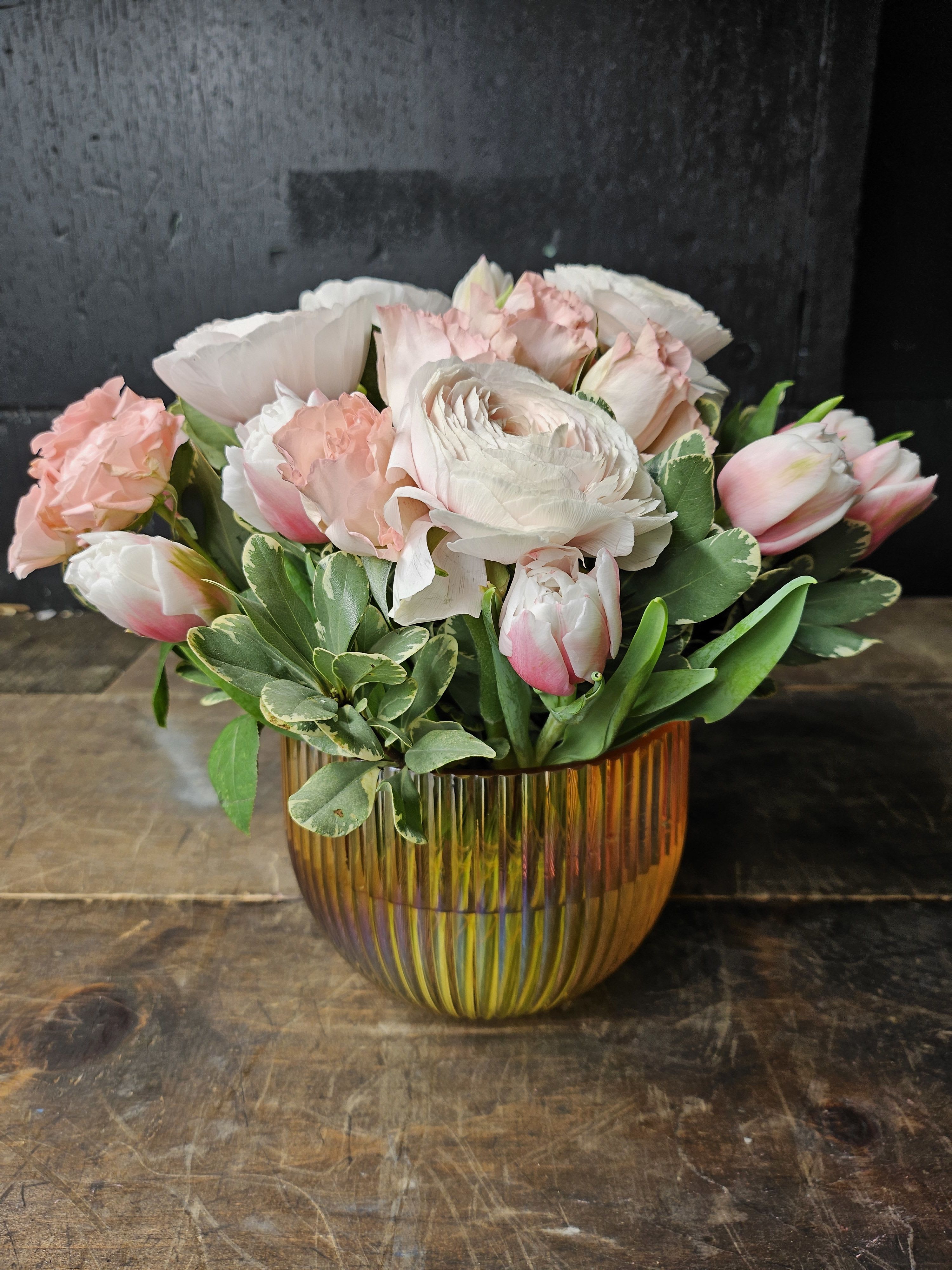 Pink and white flowers arranged in an amber glass vase