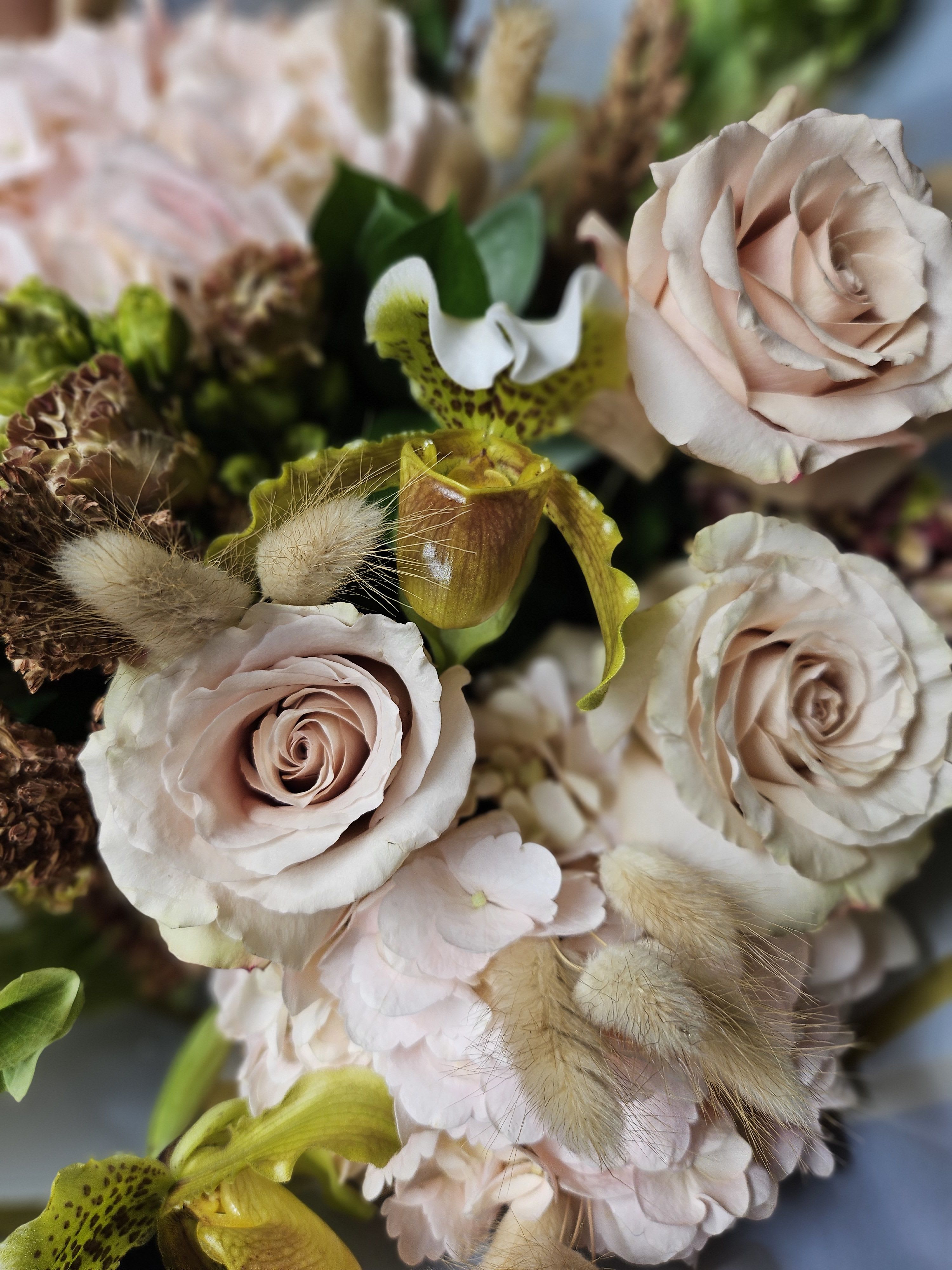 Bouquet of pale pink roses and orchids with fuzzy accents
