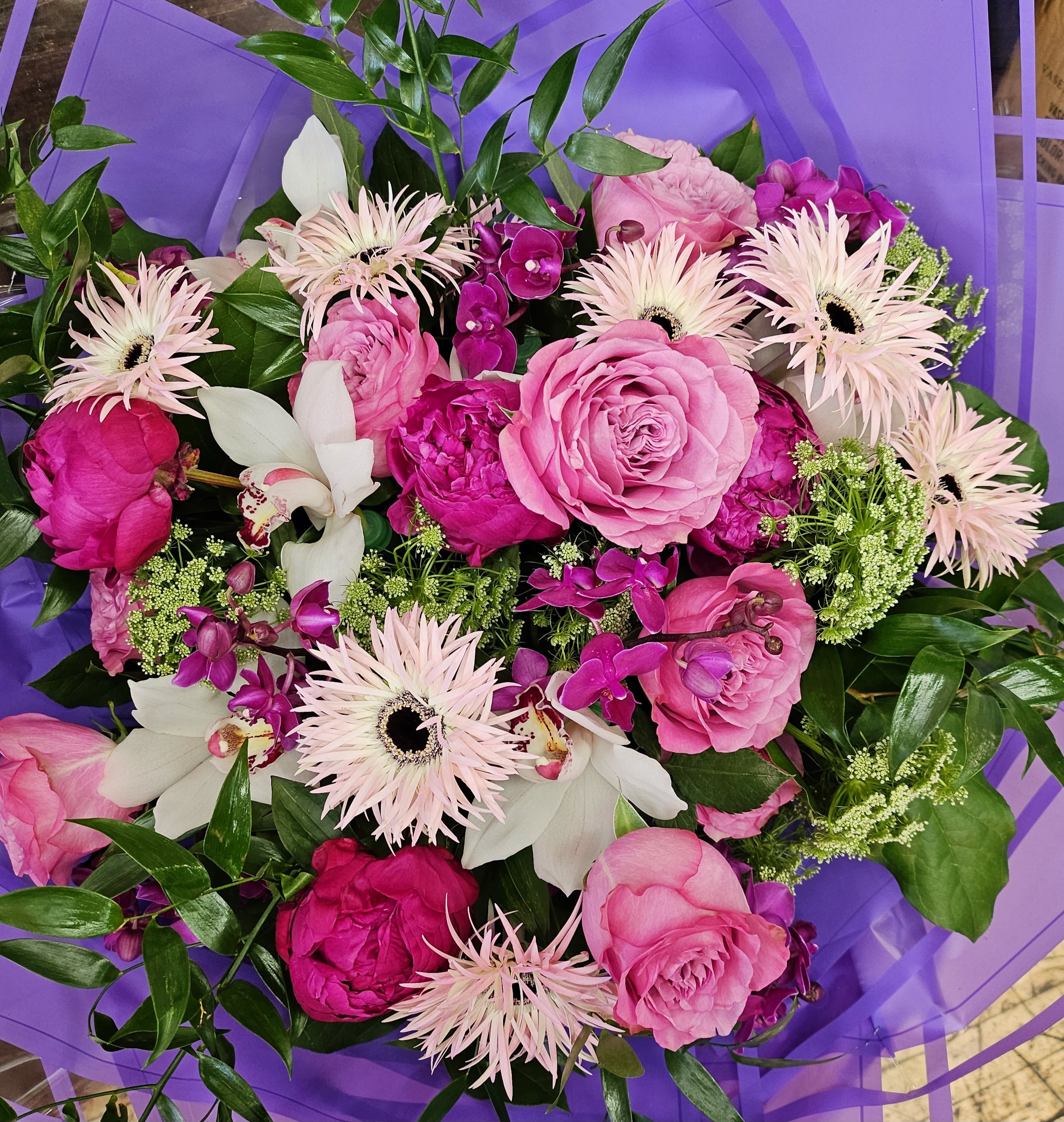 Pink and white mixed bouquet wrapped in purple paper