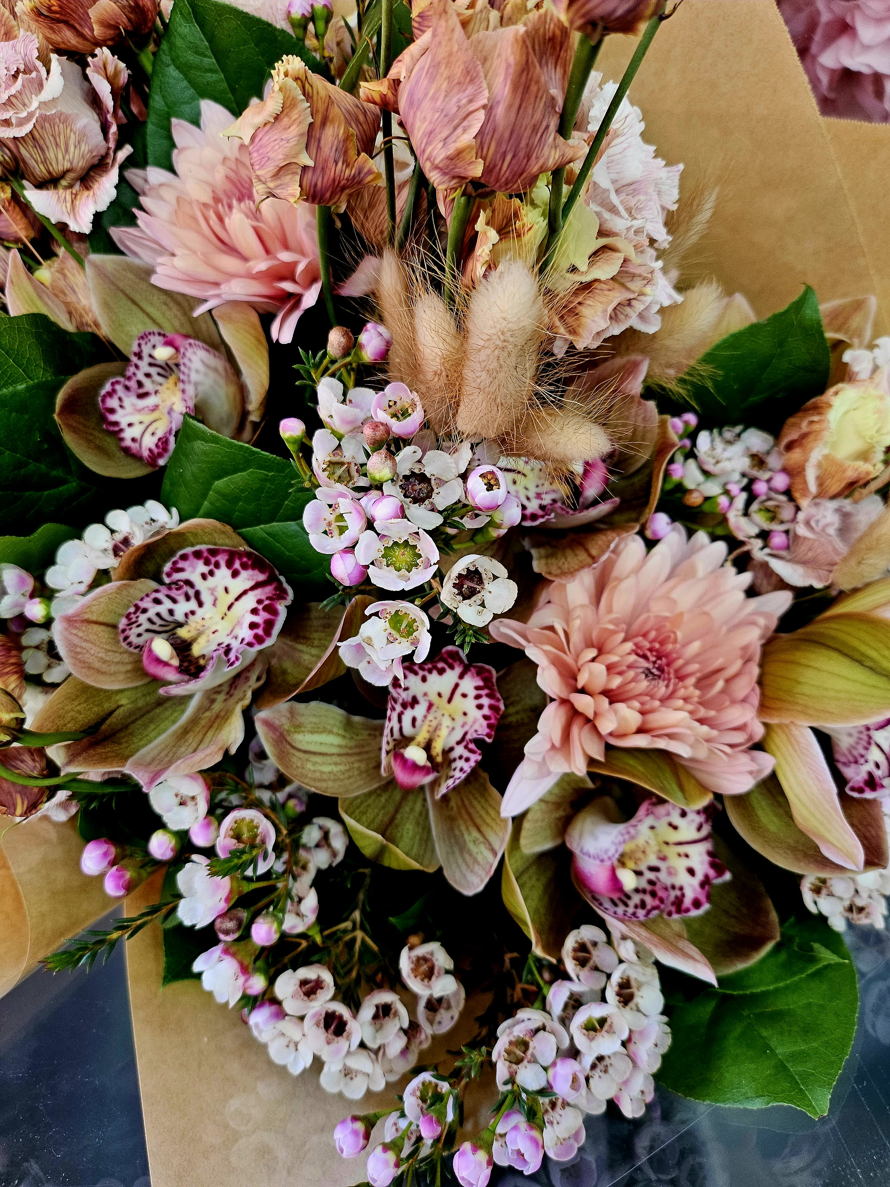 Bouquet of pink and cream flowers with spotted orchids and small white blossoms