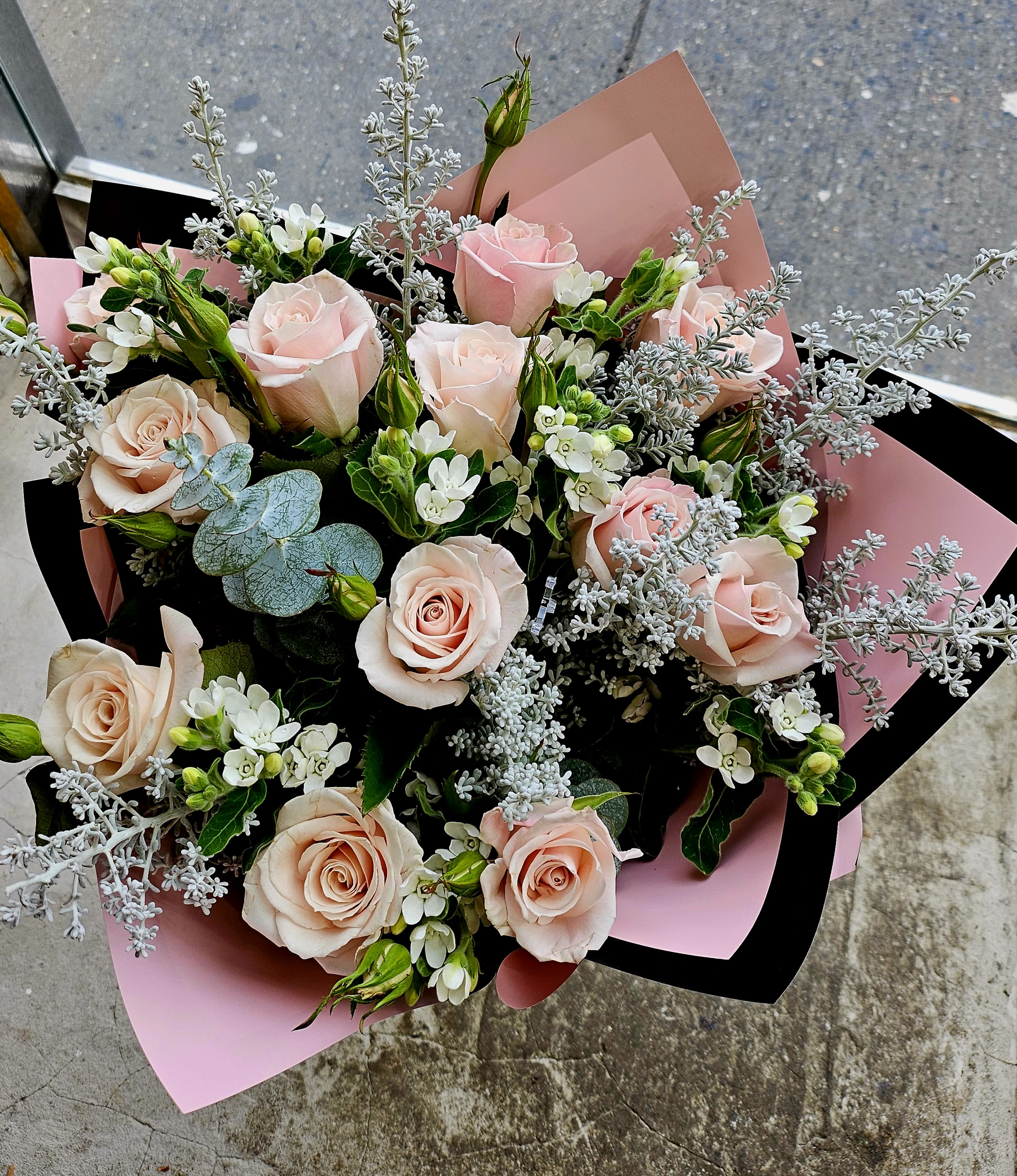 Bouquet of pale pink roses with white filler flowers and silver foliage