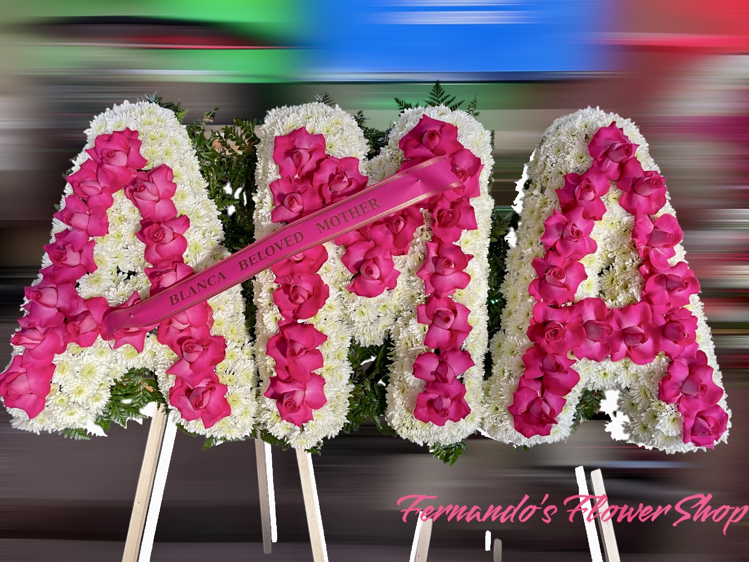 Standing floral letters with white blooms and hot pink roses spelling AMA with memorial ribbon