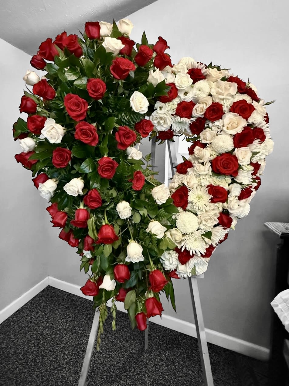 Heart-shaped standing spray of red and white roses on an easel