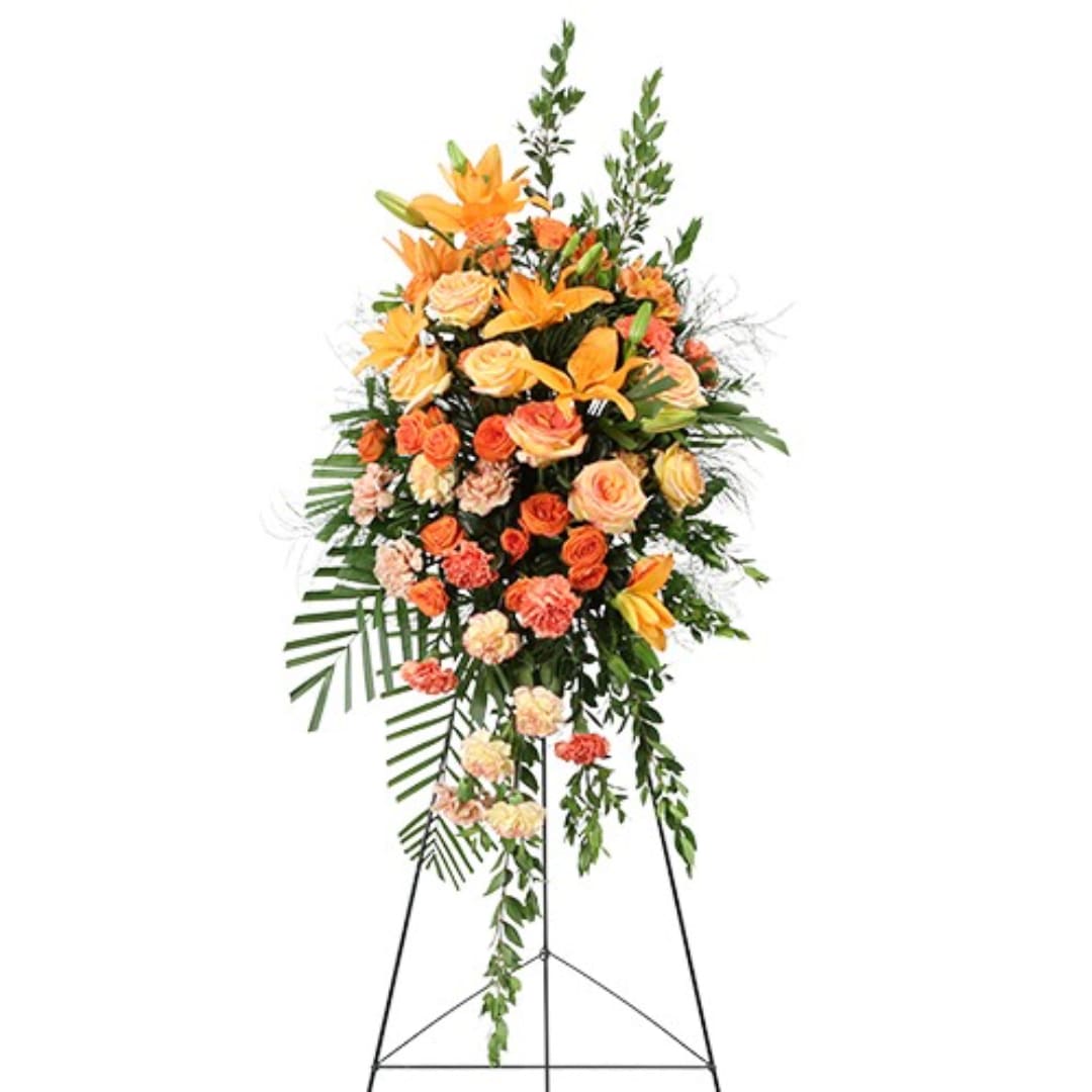 Orange and peach floral standing spray on a black easel