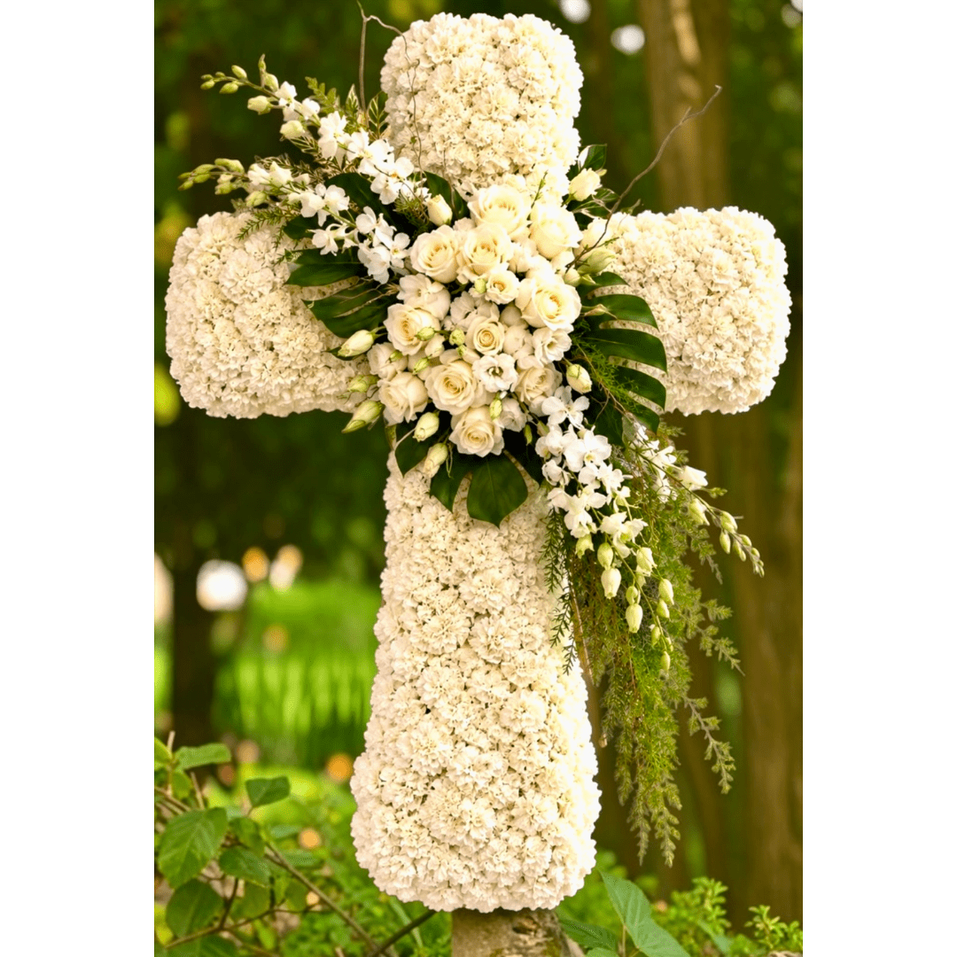 White floral cross with roses and hydrangeas outdoors