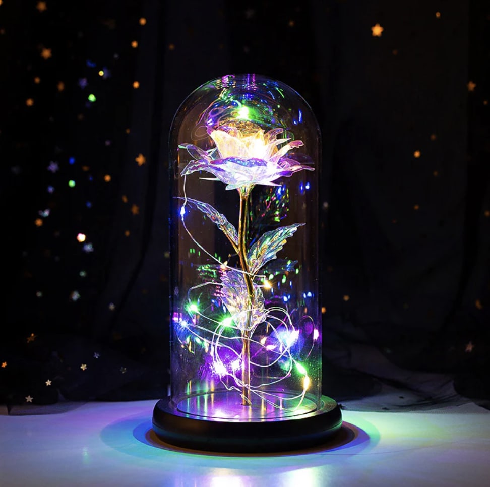 Glowing artificial flower under a glass dome with multicolor lights