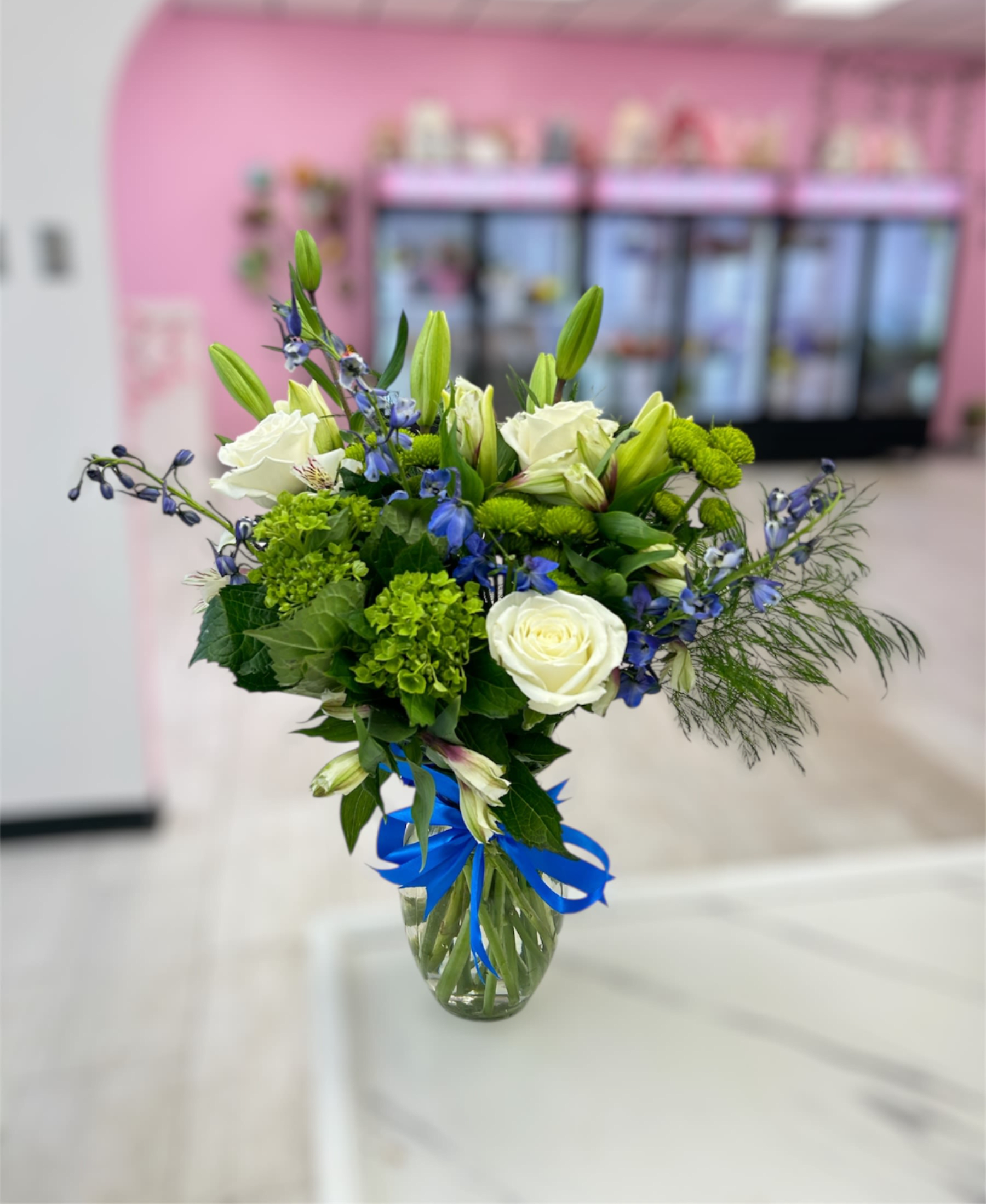Breezy by the Sea by BloomNation™ - This arrangement contains delphinium, lilies, hydrangea. It is a great gift for a birthday, get well, for wishing someone a fresh start. APPROXIMATE DIMENSIONS: 15" D x 18" H