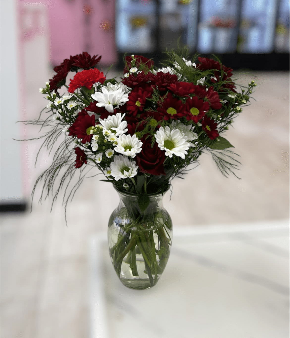 Boldly Bashful by BloomNation™ - This bouquet is a sweet way to show someone you care. Boldly Bashful by BloomNation™ is a great gift for Valentine's Day or Birthday.   Arrangement Details: Includes white chrystanthemum spray daisies, pink carnations, and red roses.  APPROXIMATE DIMENSIONS: 12" H X 10" W
