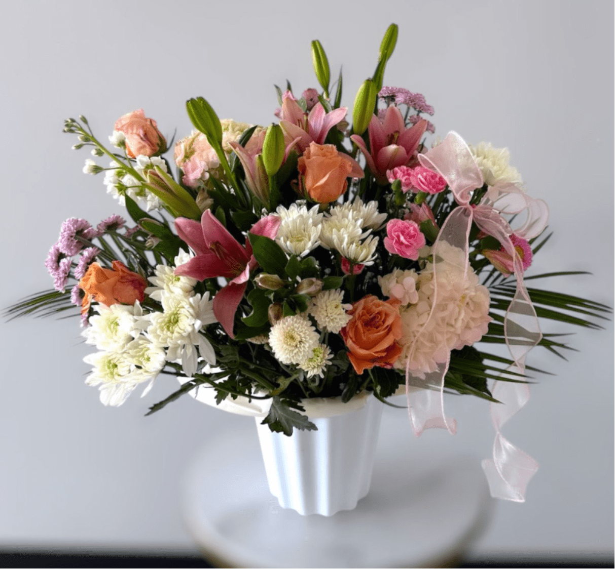 Pink &amp; White Floor Basket - Pink and White Mixed Flowers In White Floor Basket . Please note that florists may need to make substitutions based on inventory to ensure the freshest blooms are delivered, while maintaining the arrangement's overall aesthetic.