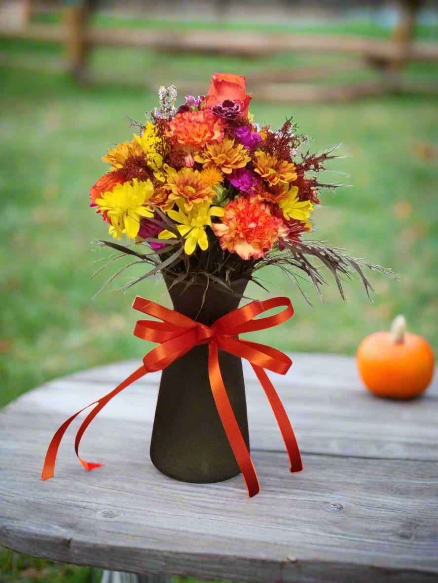 Autumn bouquet in a black vase with a red ribbon