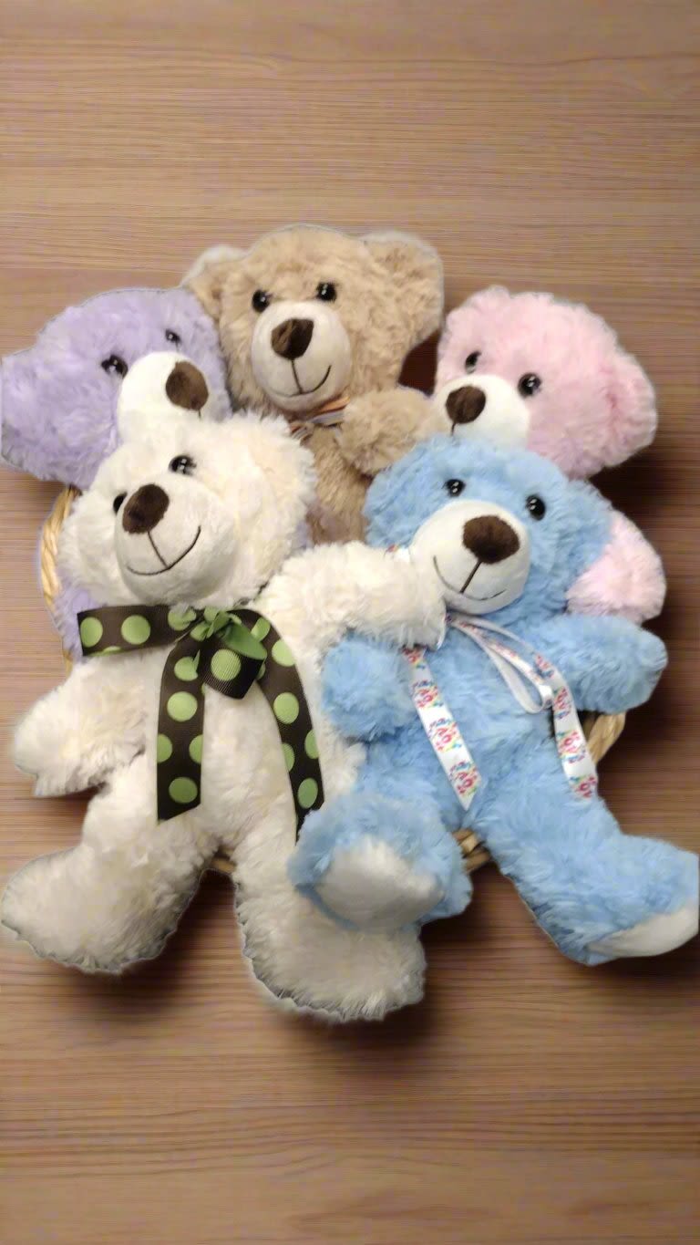 Five plush teddy bears in pastel colors arranged in a basket