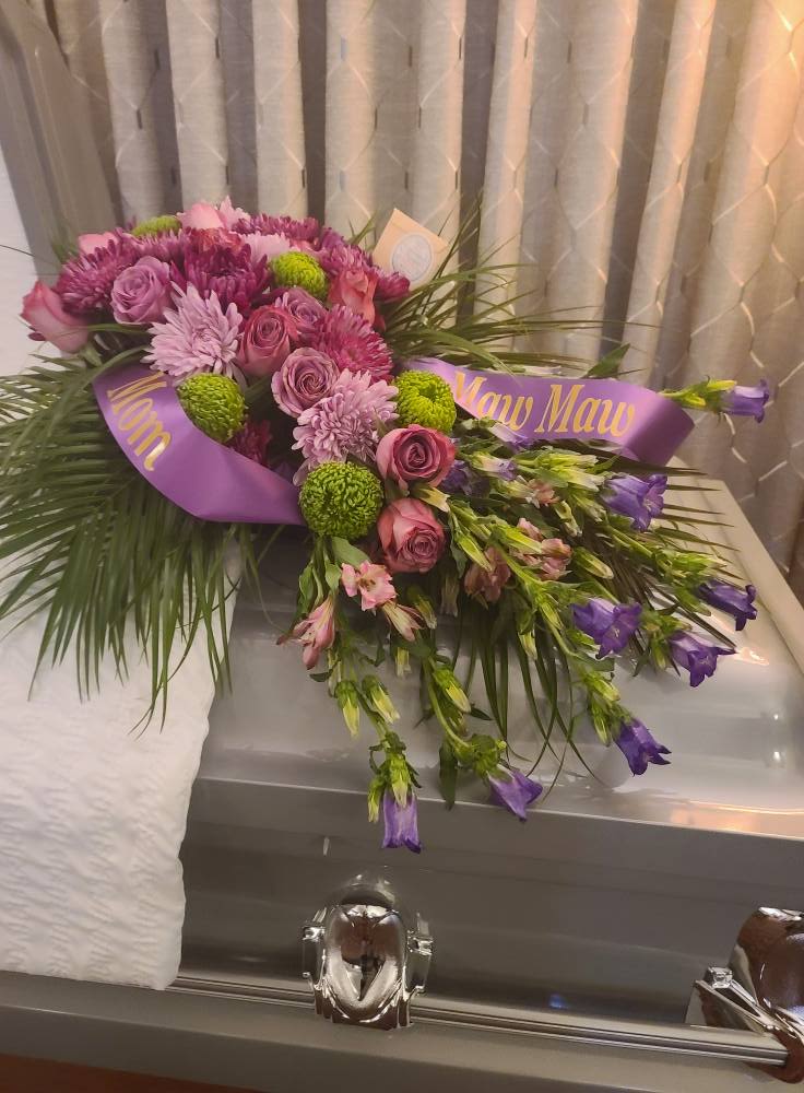 Purple and pink floral casket spray with ribbon