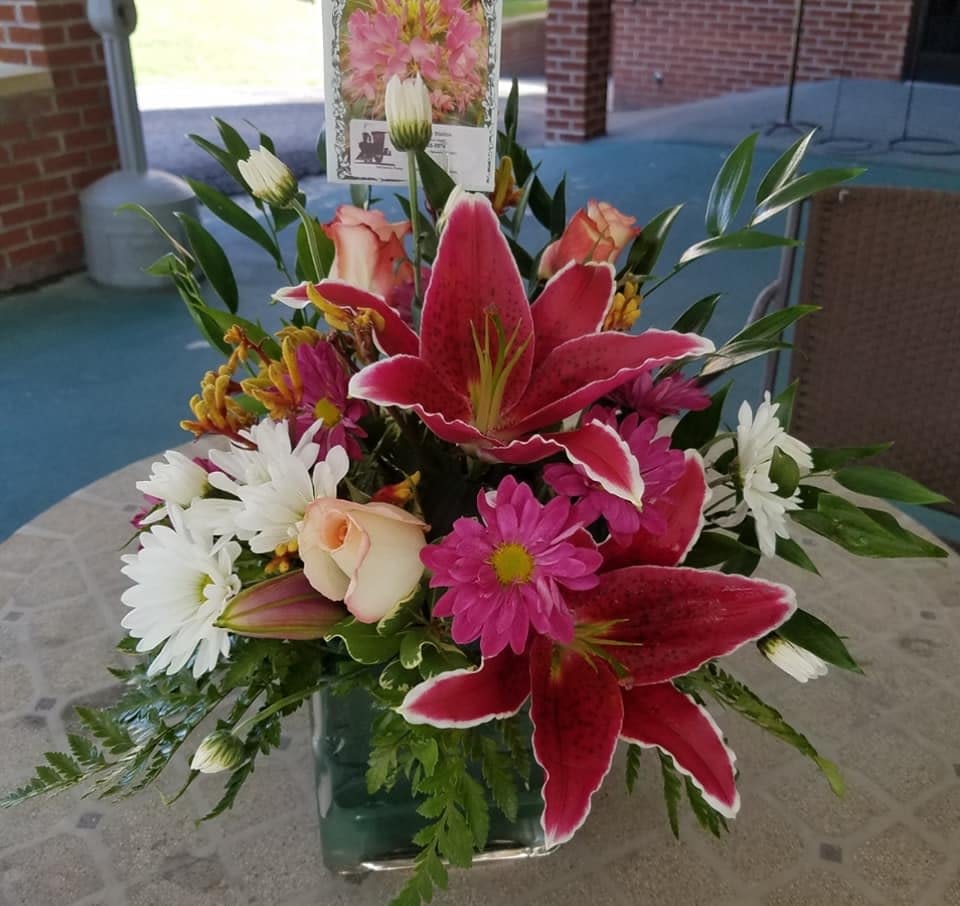 Bouquet of pink lilies, white daisies, and roses in a glass vase