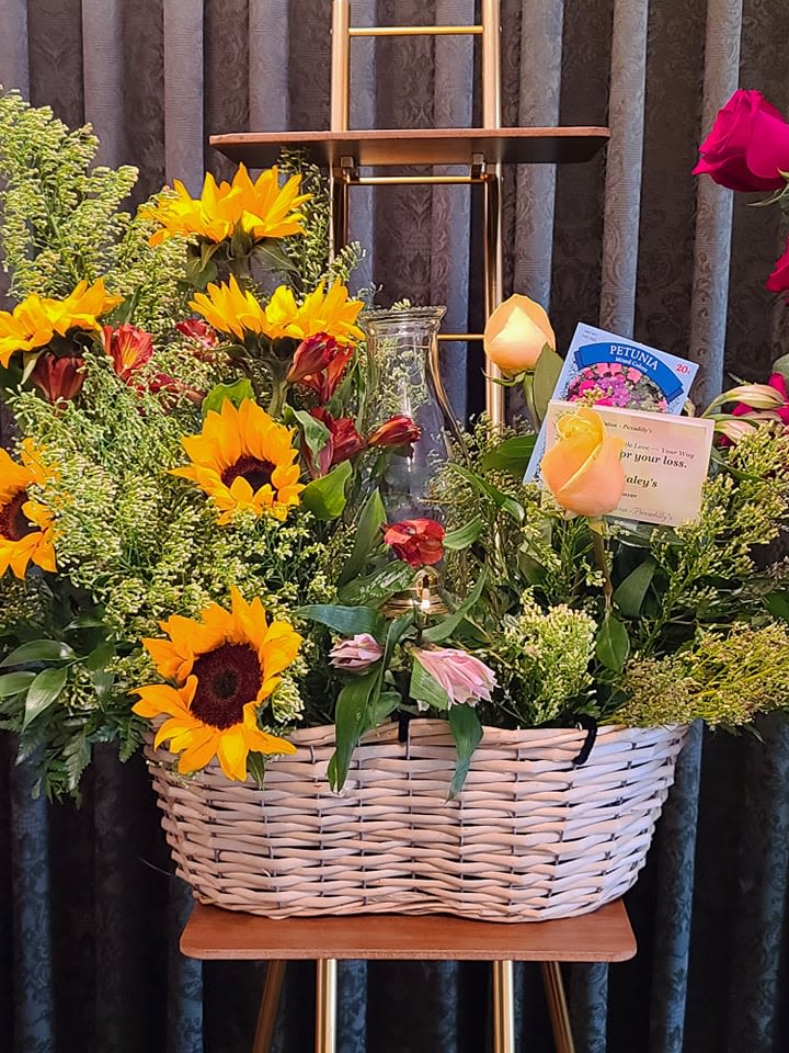Basket arrangement with sunflowers, roses, and mixed greenery