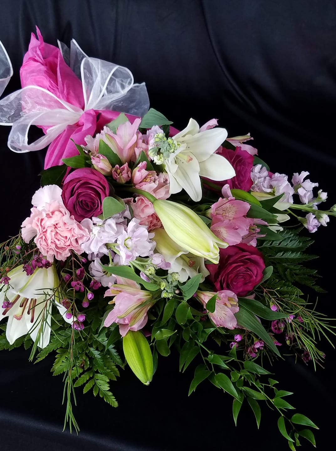 Pink and white mixed bouquet with lilies and roses tied with a ribbon