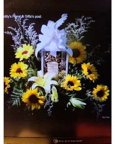 Sunflower and lily funeral spray with a white bow and framed photo