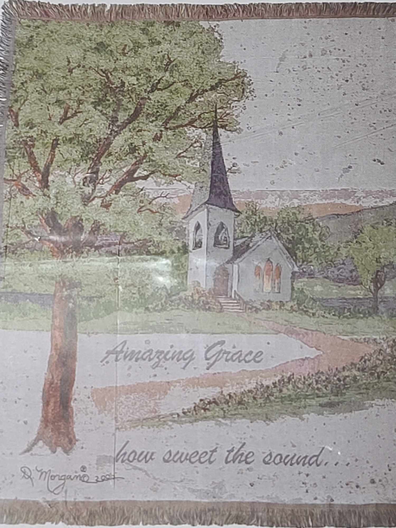 Framed painting of a church with a tall steeple and large tree