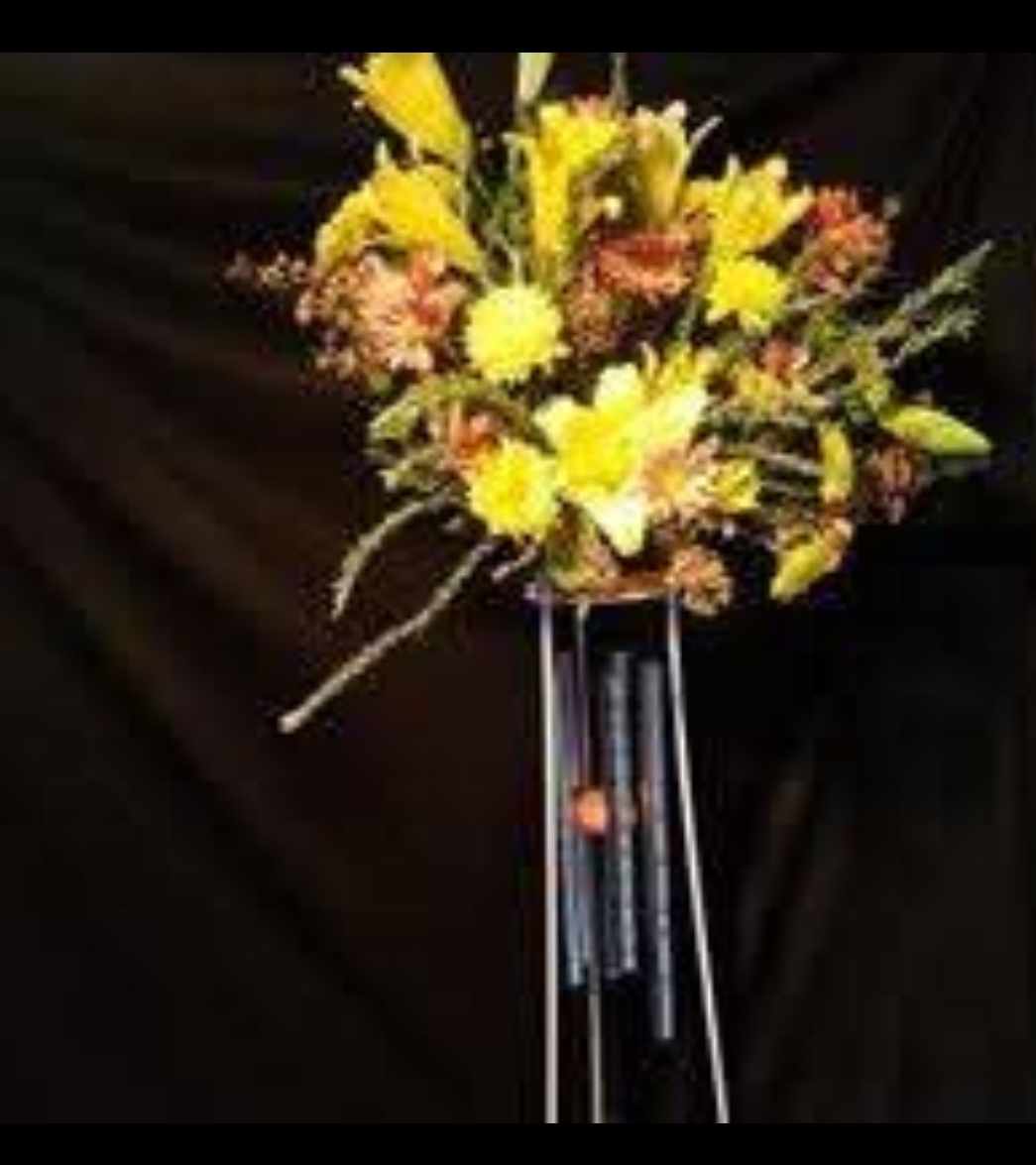 Tall yellow and orange floral arrangement on a stand