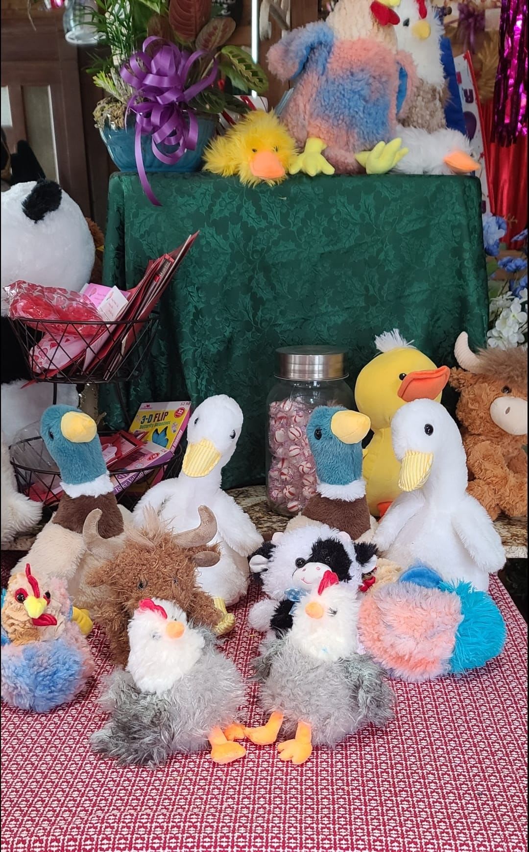 Plush duck and bird toys arranged around a small gift display