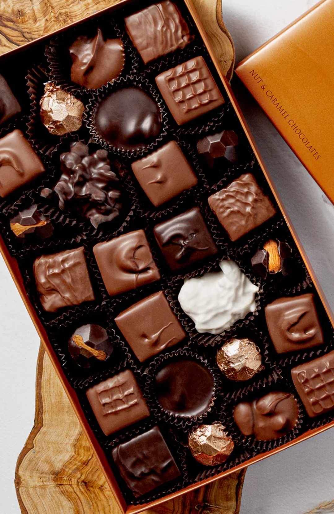 Box of assorted chocolates in black paper cups