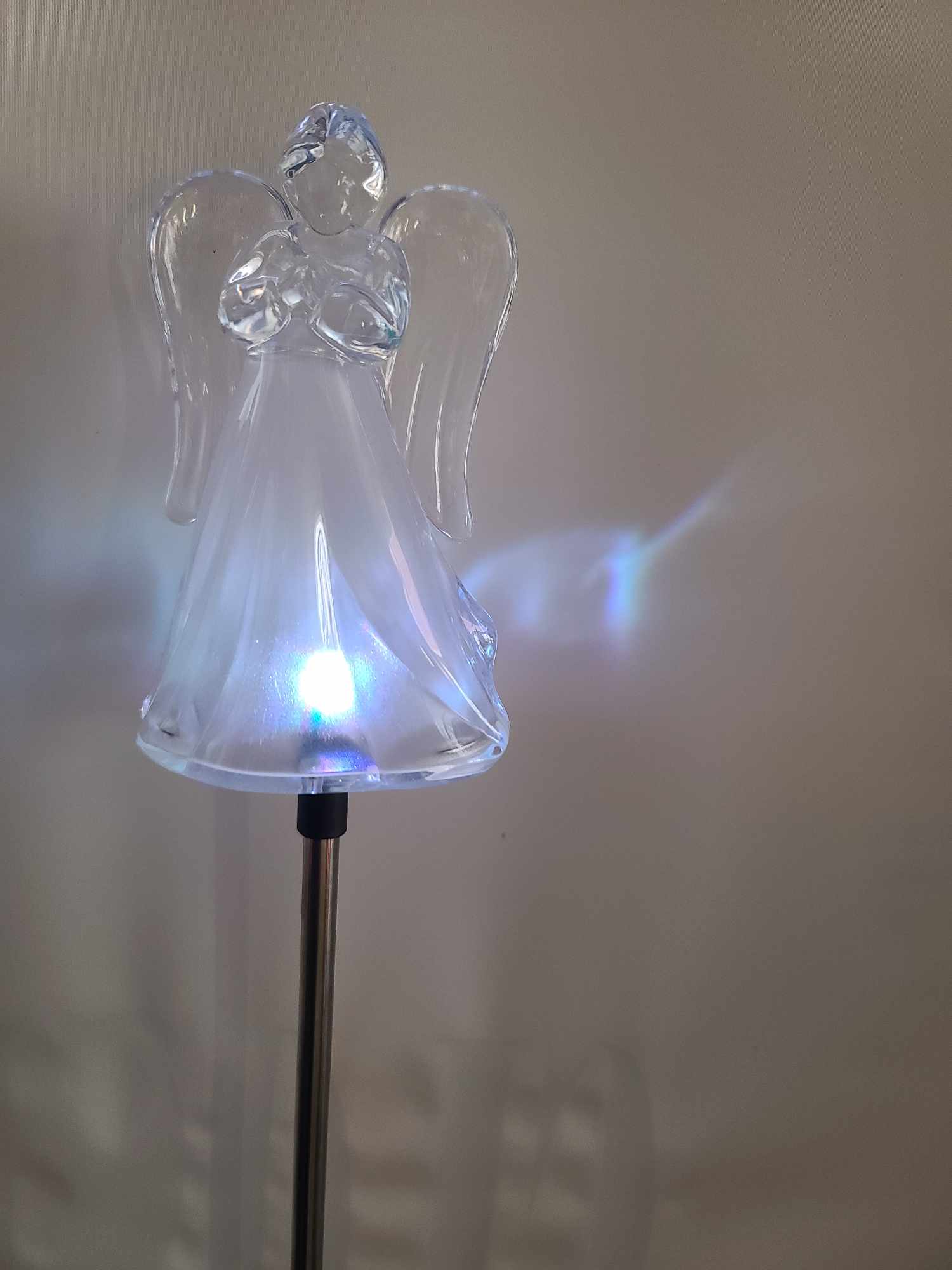 Clear glass angel figurine on a metal stand