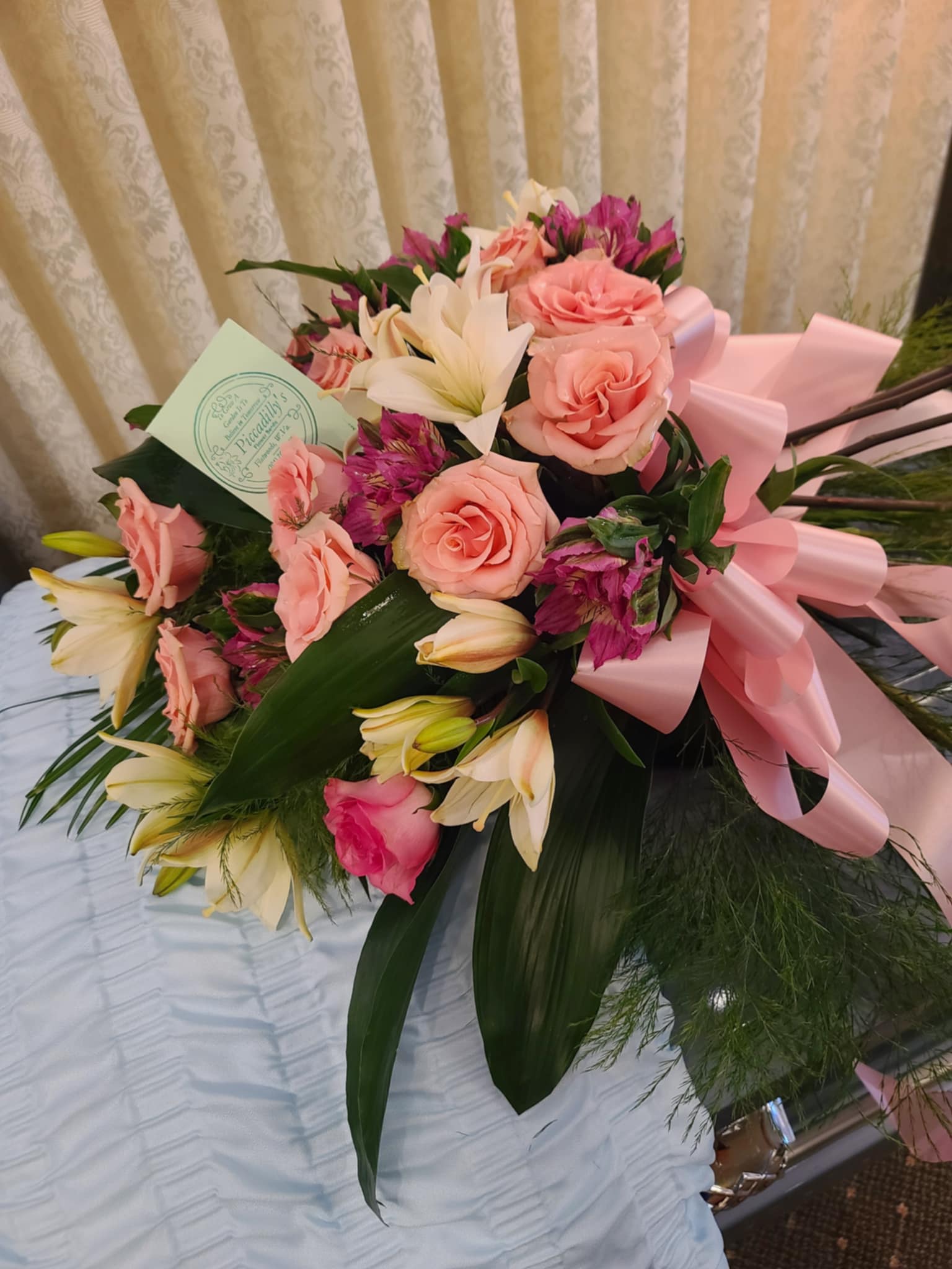 Bouquet of pink roses and white lilies with a pink ribbon