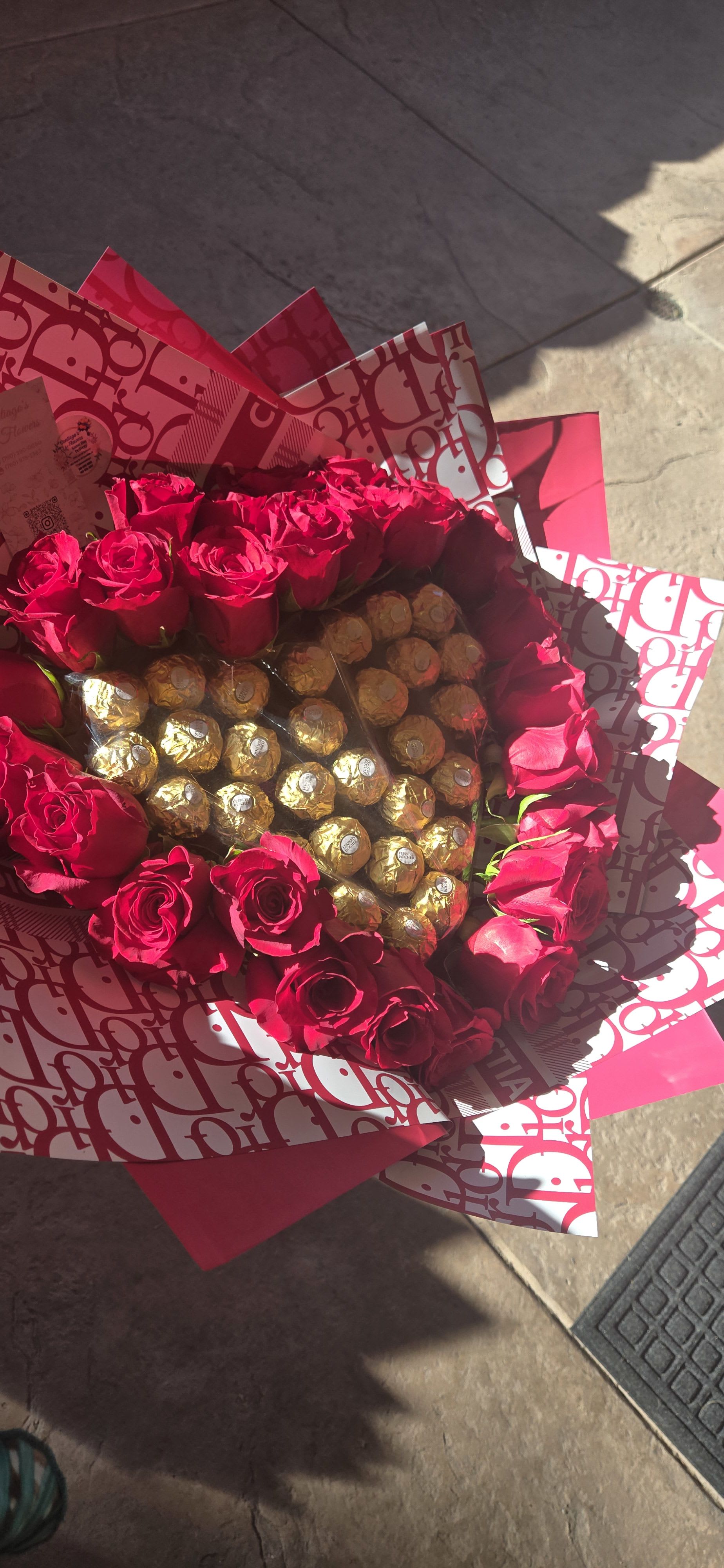 Bouquet of red roses surrounding gold-wrapped chocolates